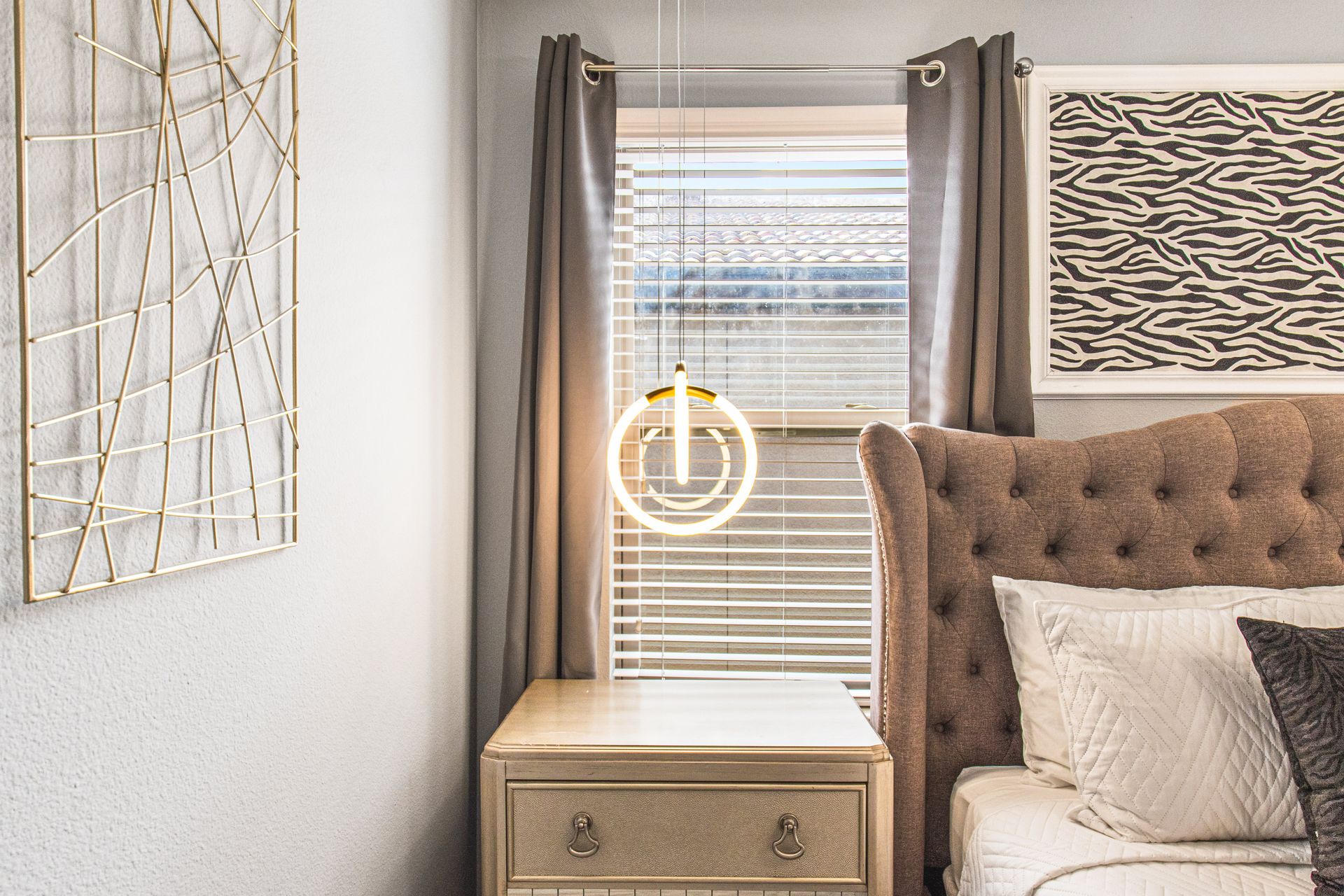 Chic bedroom with modern lighting, elegant decor, and a cozy tufted headboard!