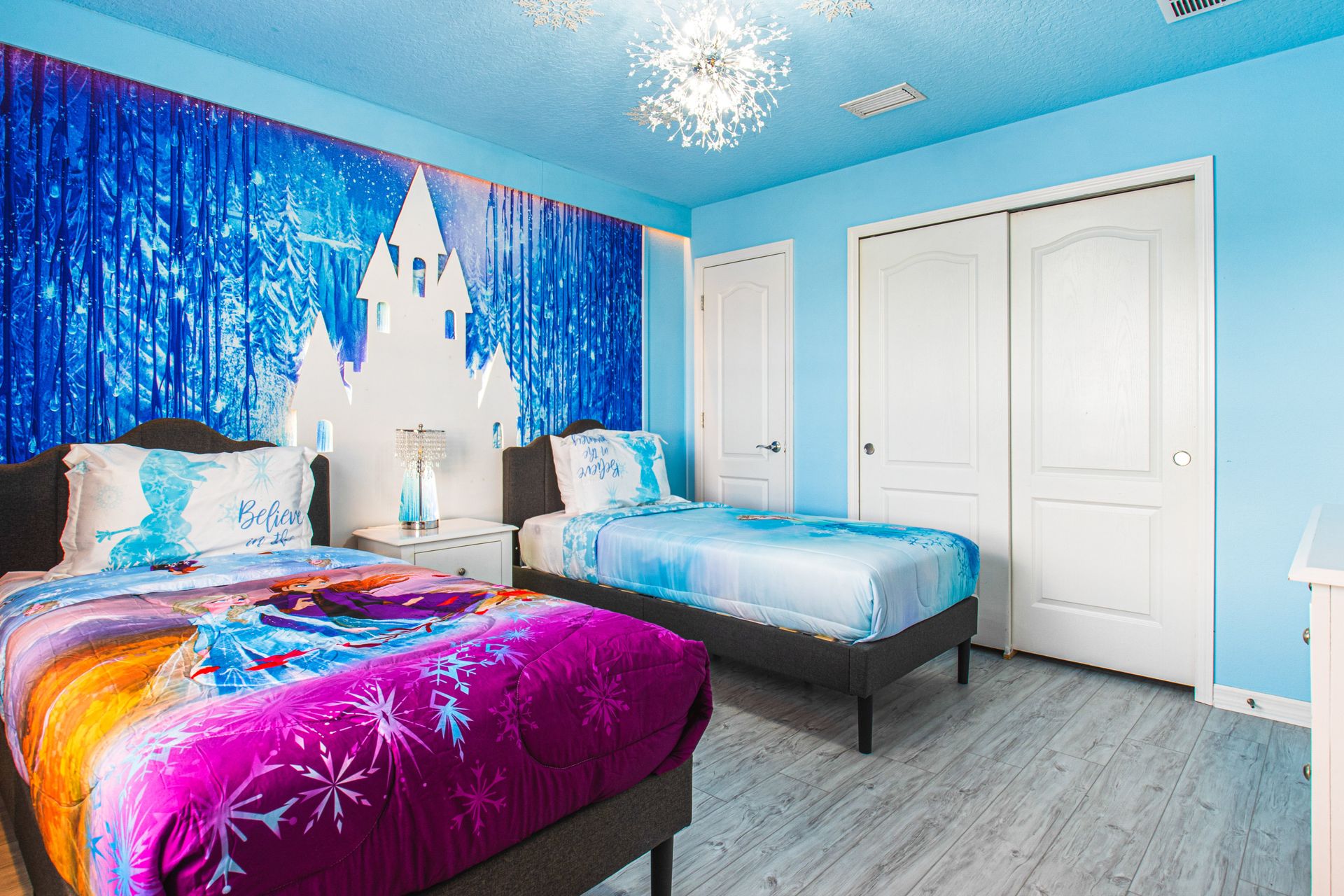 Enchanting ice castle-themed bedroom with twin beds, sparkling decor, and cozy vibes!