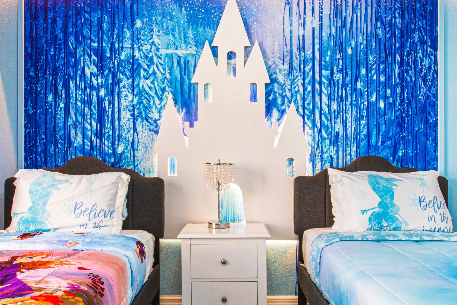Enchanting ice castle-themed bedroom with twin beds, sparkling decor, and cozy vibes!