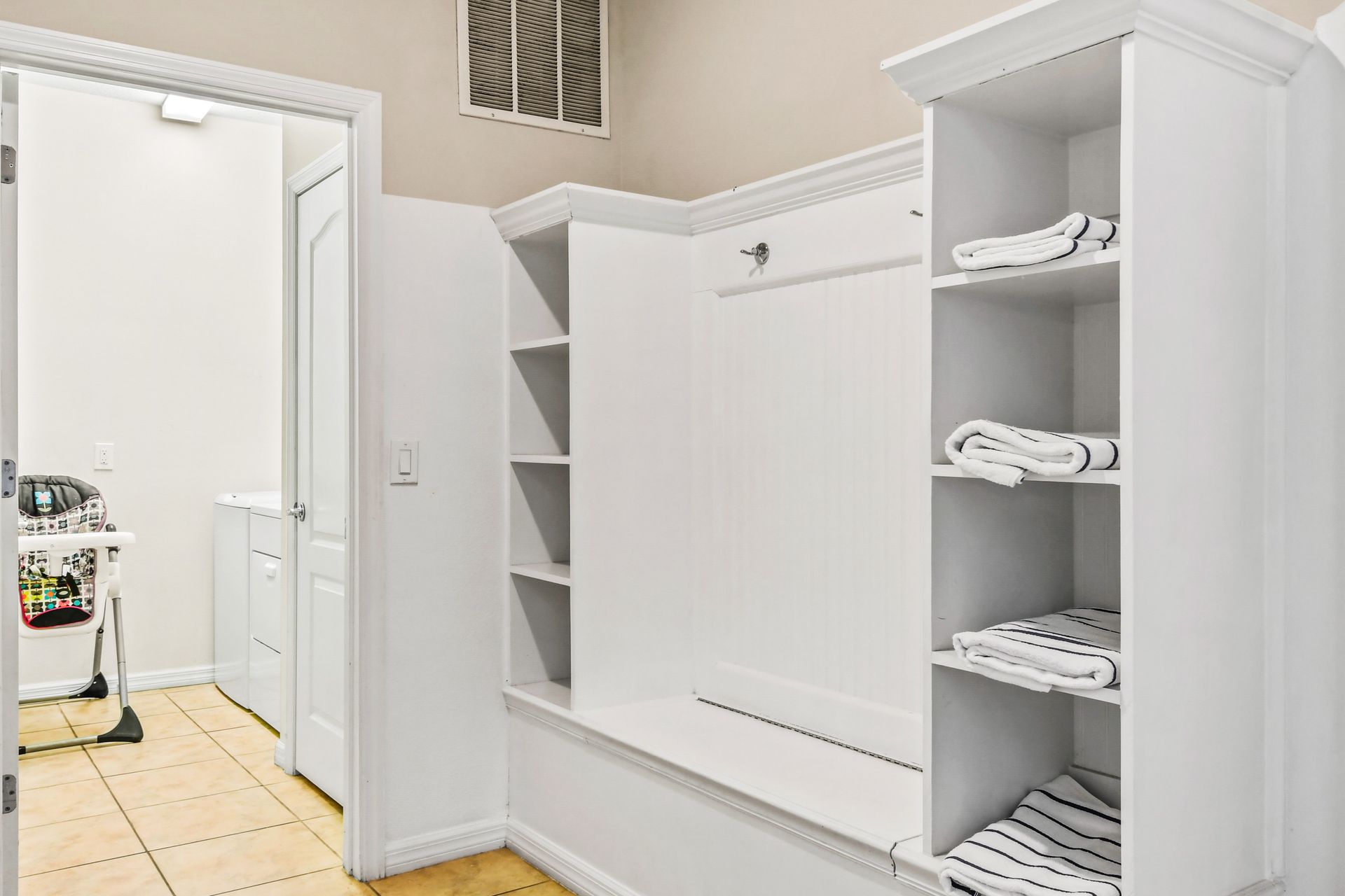 Spacious laundry and mudroom with built-in storage, fresh towels, and modern design!