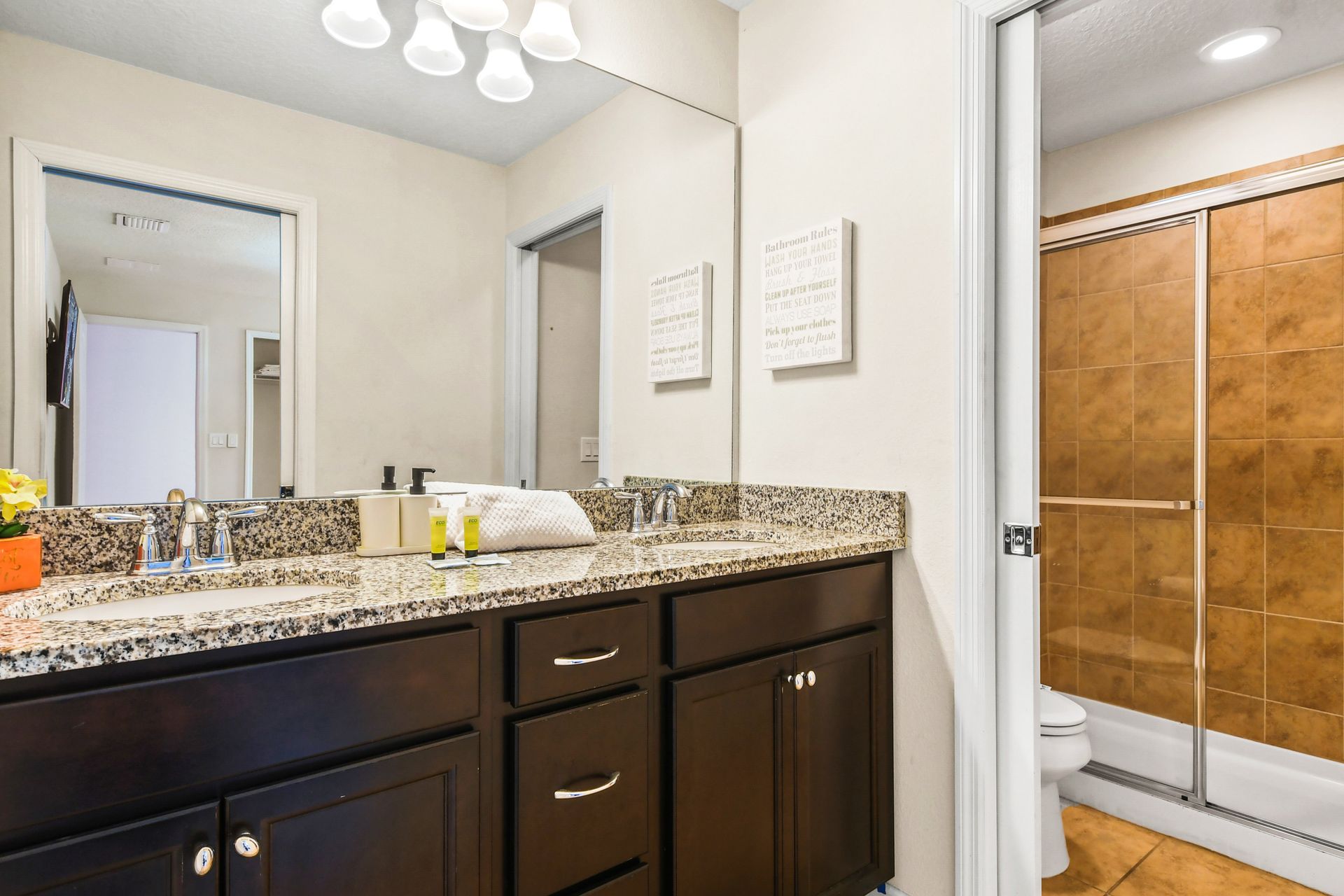Elegant bathroom with a granite double vanity, glass shower, and modern decor!