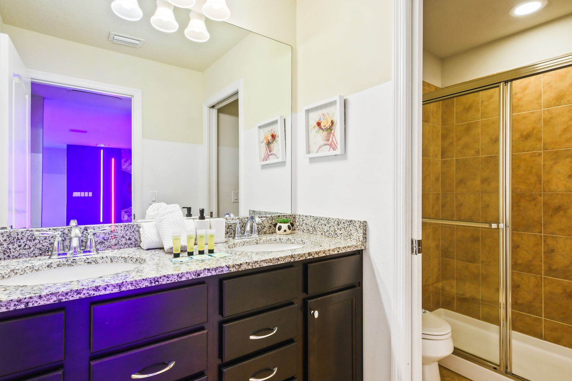 Modern bathroom with a granite double vanity, glass-enclosed shower, and elegant decor!