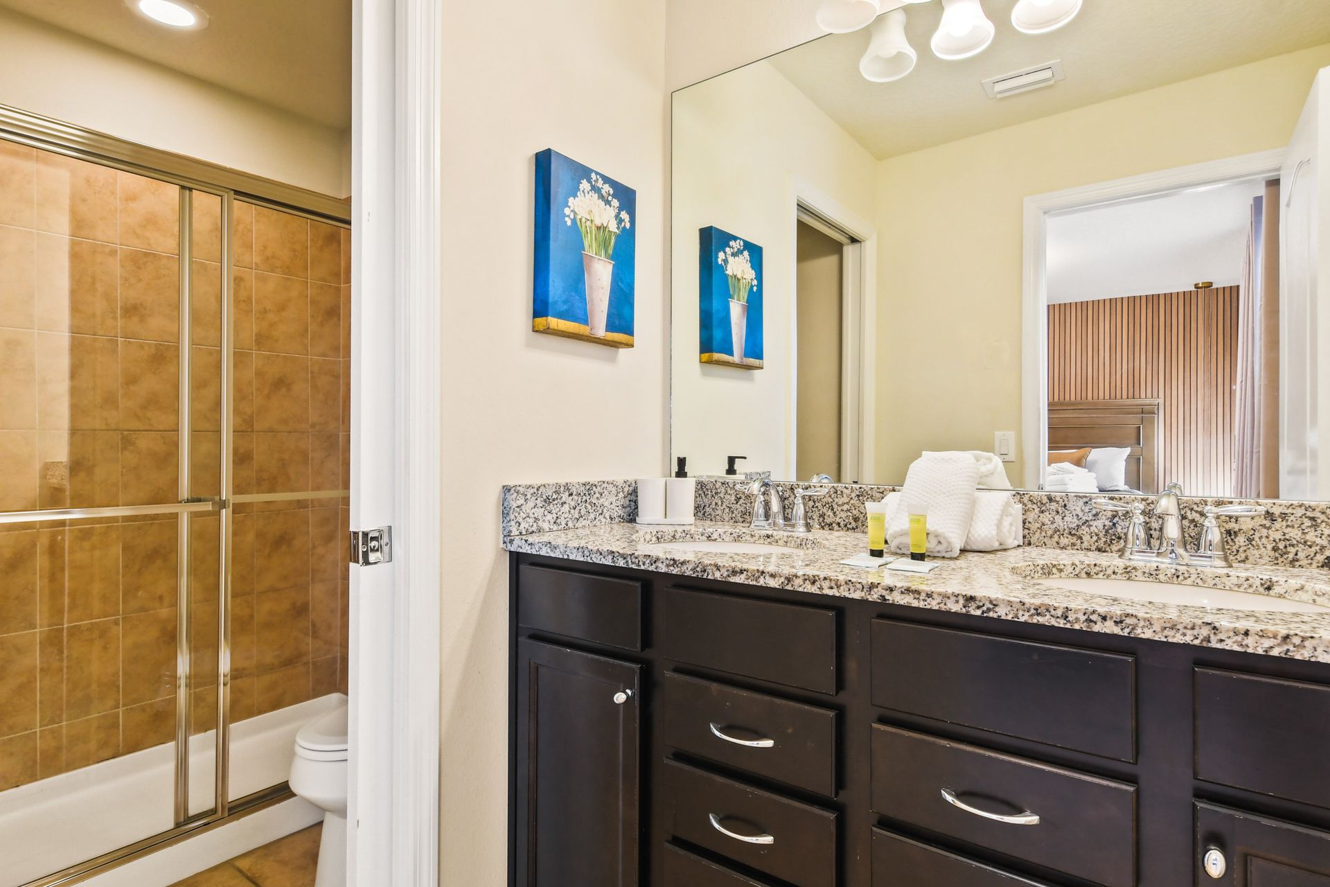 Modern bathroom with a granite double vanity, glass shower, and stylish decor!