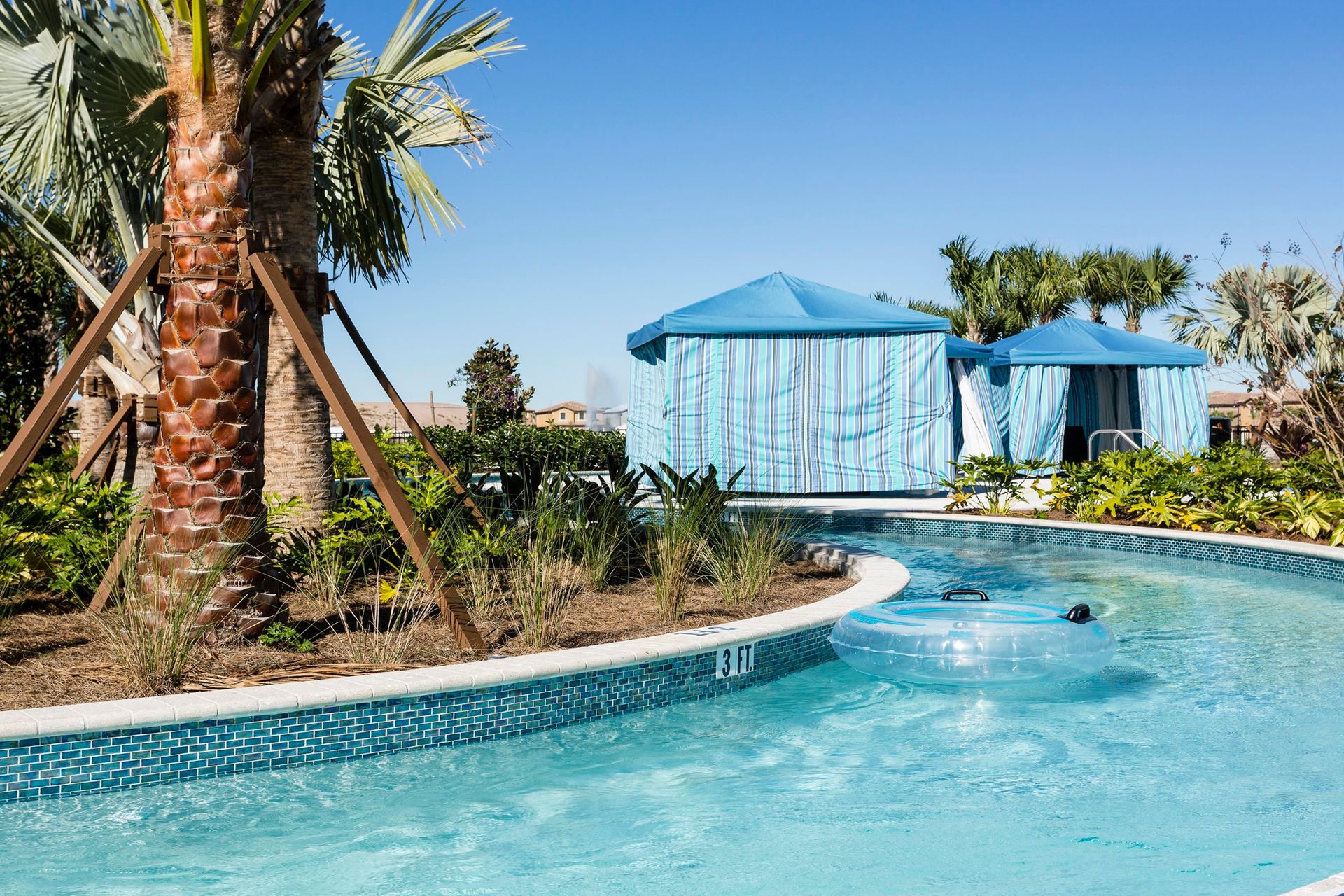 Relax and float along the lazy river, surrounded by lush greenery and private cabanas for ultimate leisure.