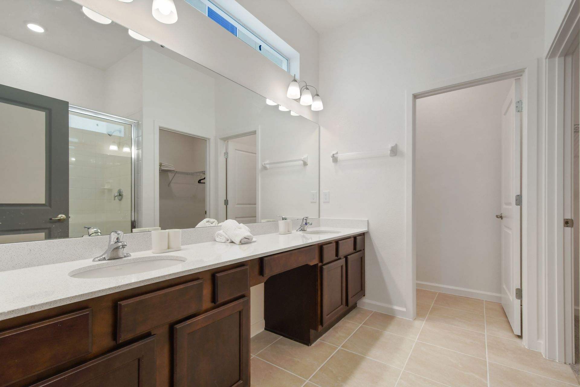 Spacious bathroom with dual sinks, walk-in shower, and bright natural lighting.
