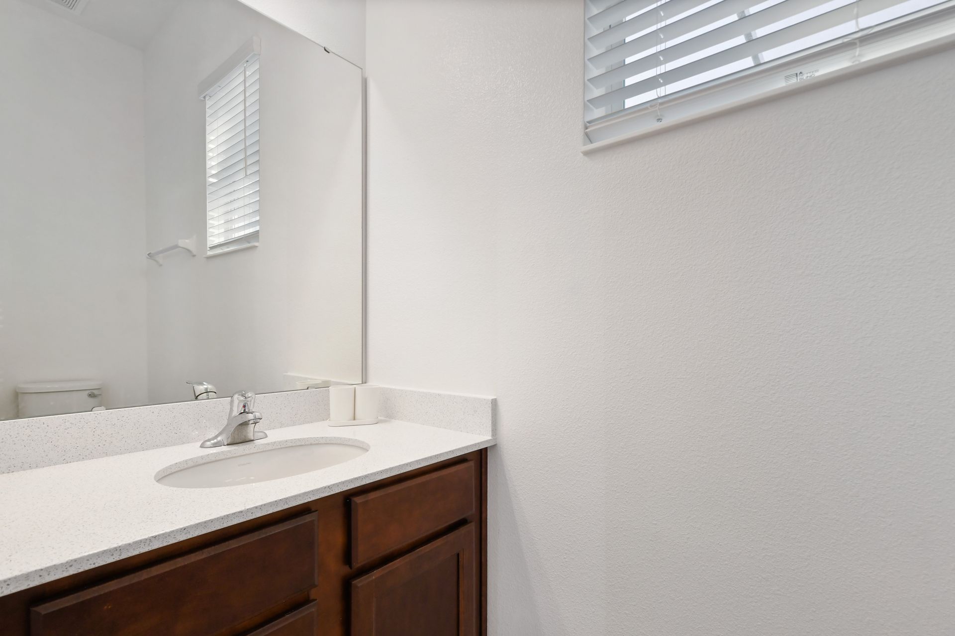 Bright and simple bathroom with tropical shower curtain and clean modern finish.
