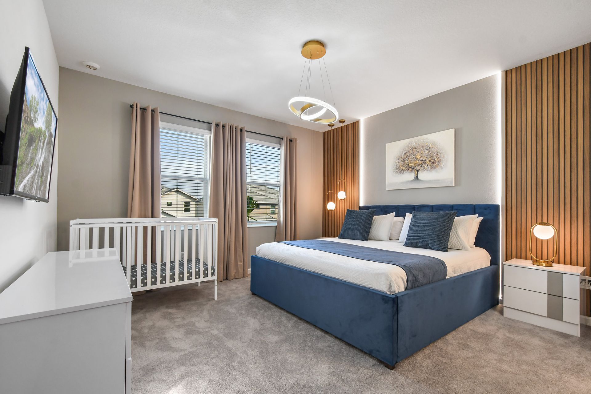 Serene family suite with king bed, modern crib, and warm natural lighting.
