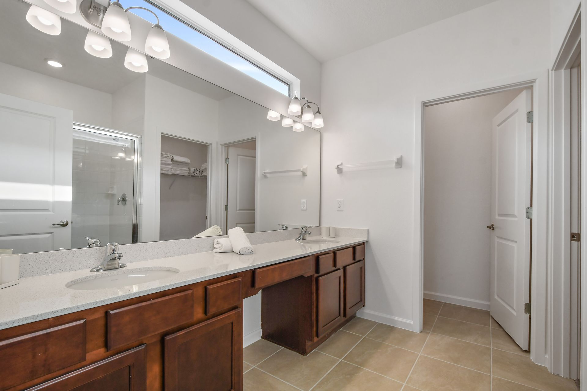 Spacious bathroom with dual sinks, walk-in shower, and bright natural lighting.
