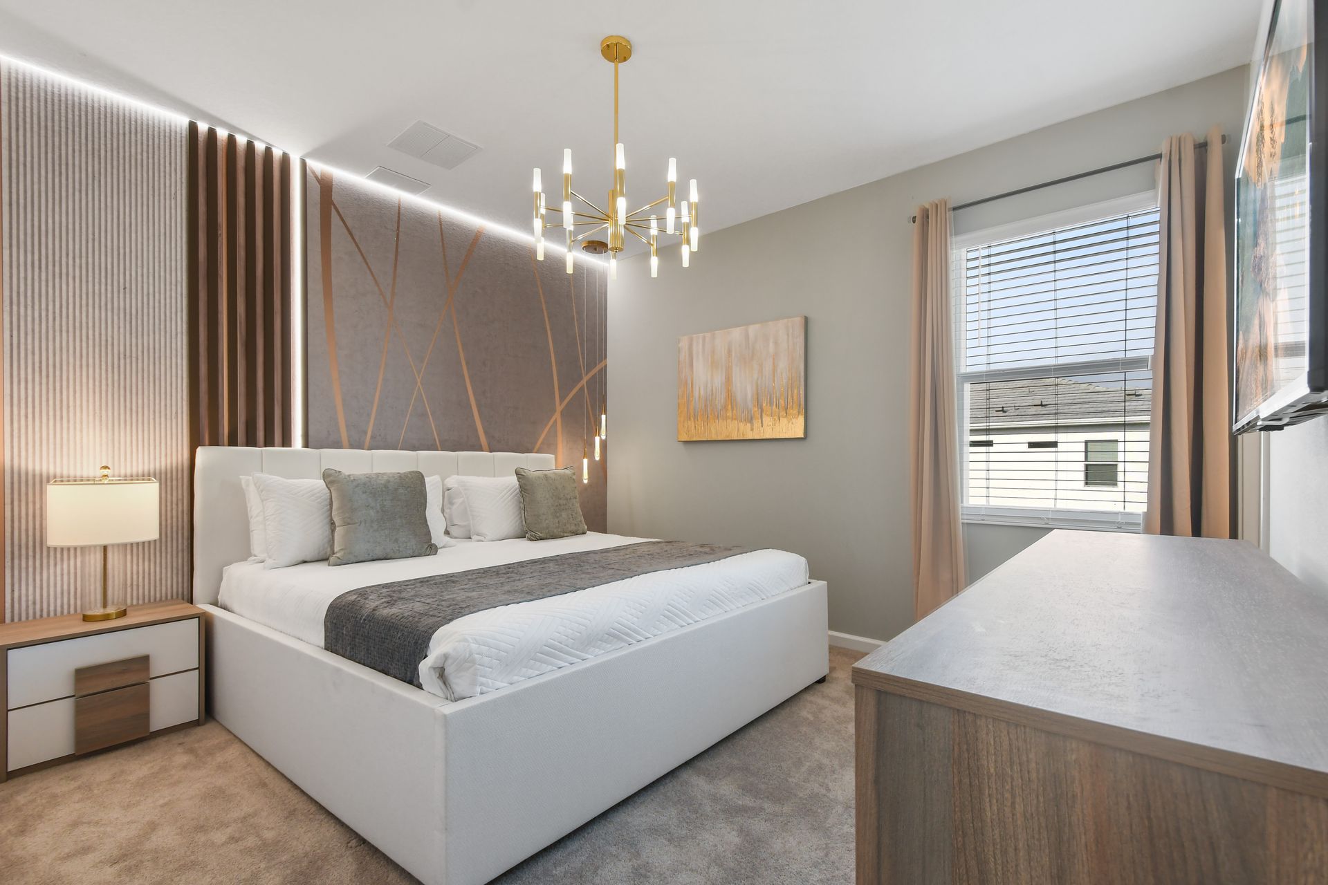 Refined bedroom with modern chandelier, king bed, and elegant accent wall.

