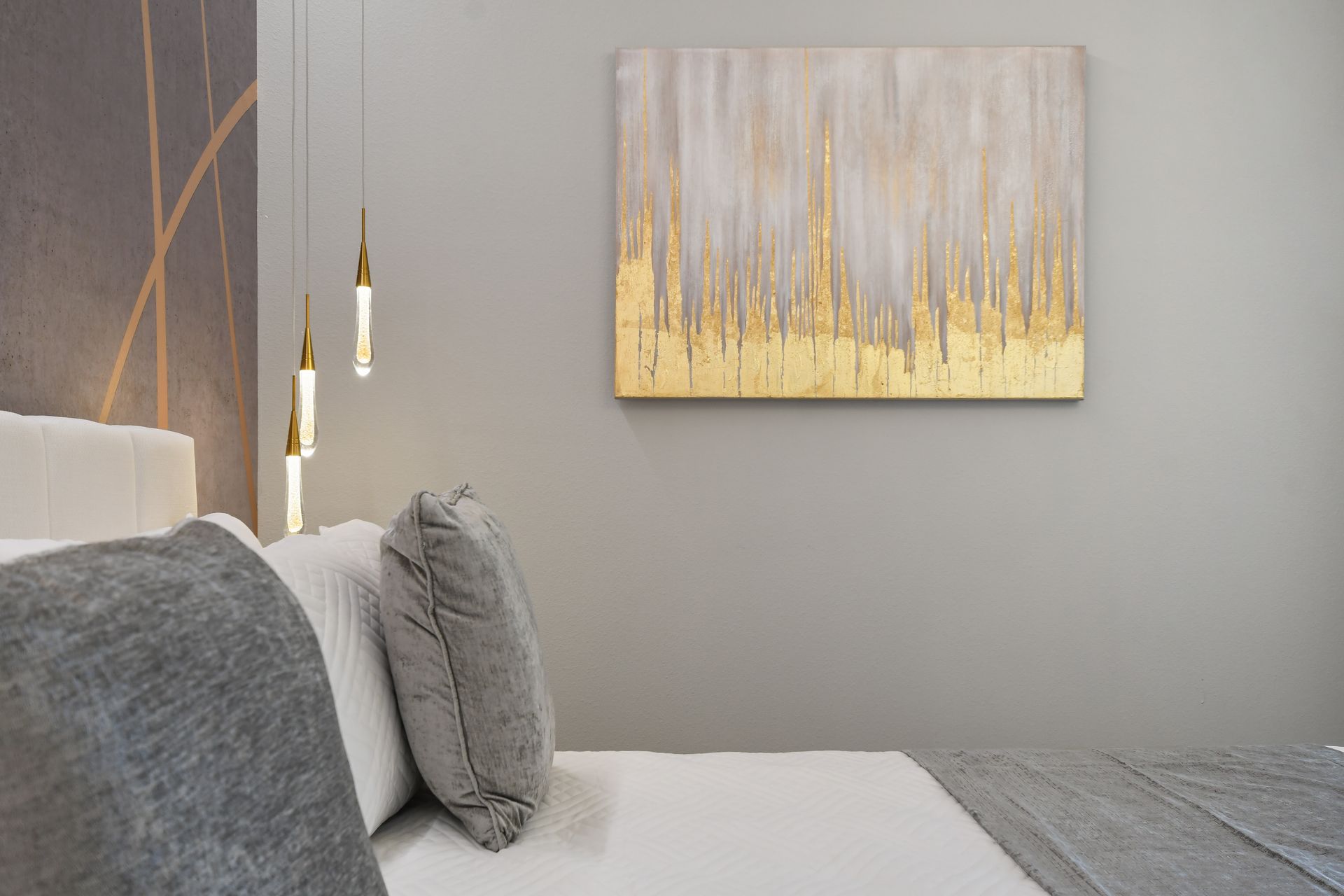 Refined bedroom with modern chandelier, king bed, and elegant accent wall.
