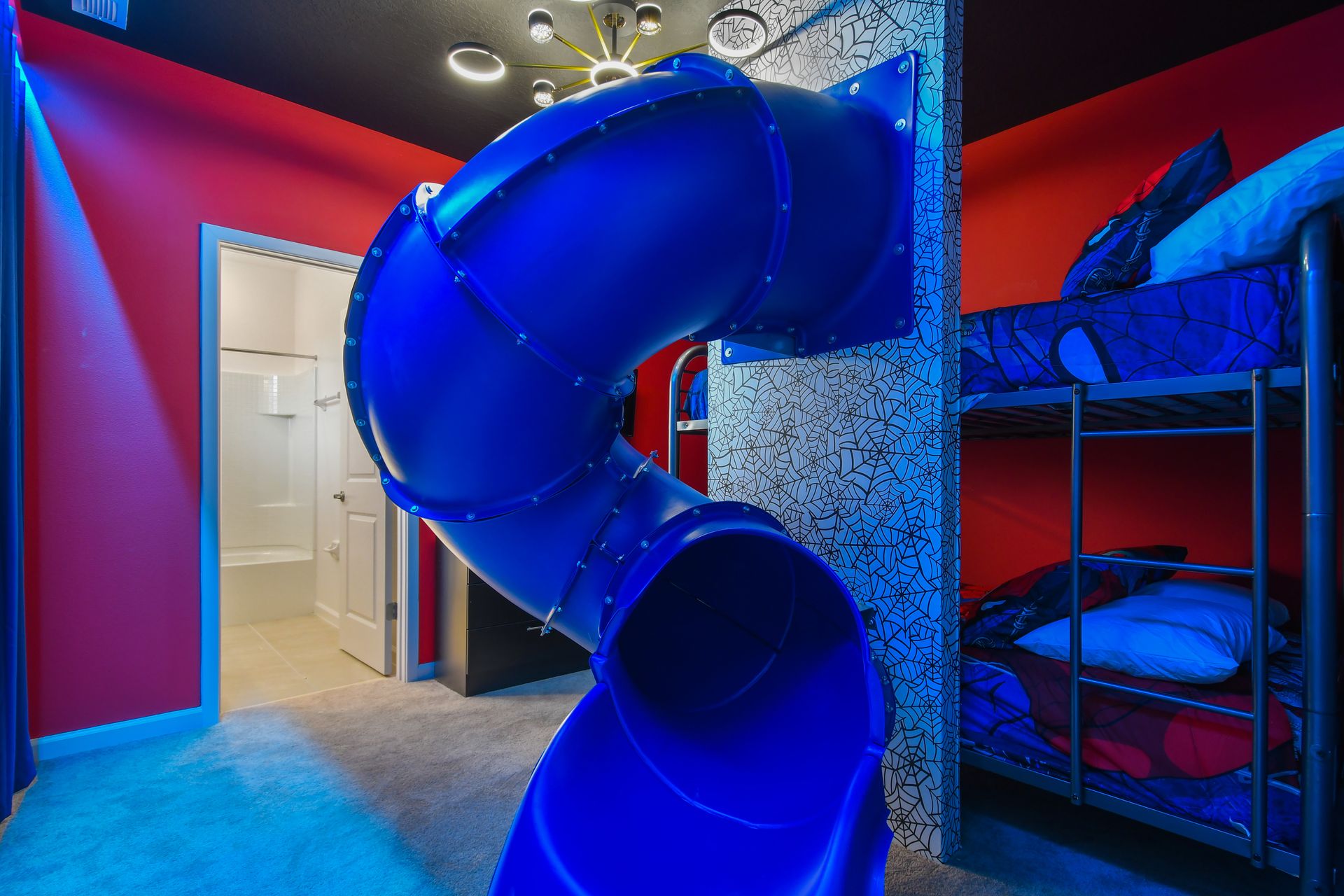 Slide into fun in this superhero-themed bunk room with bold colors and style.
