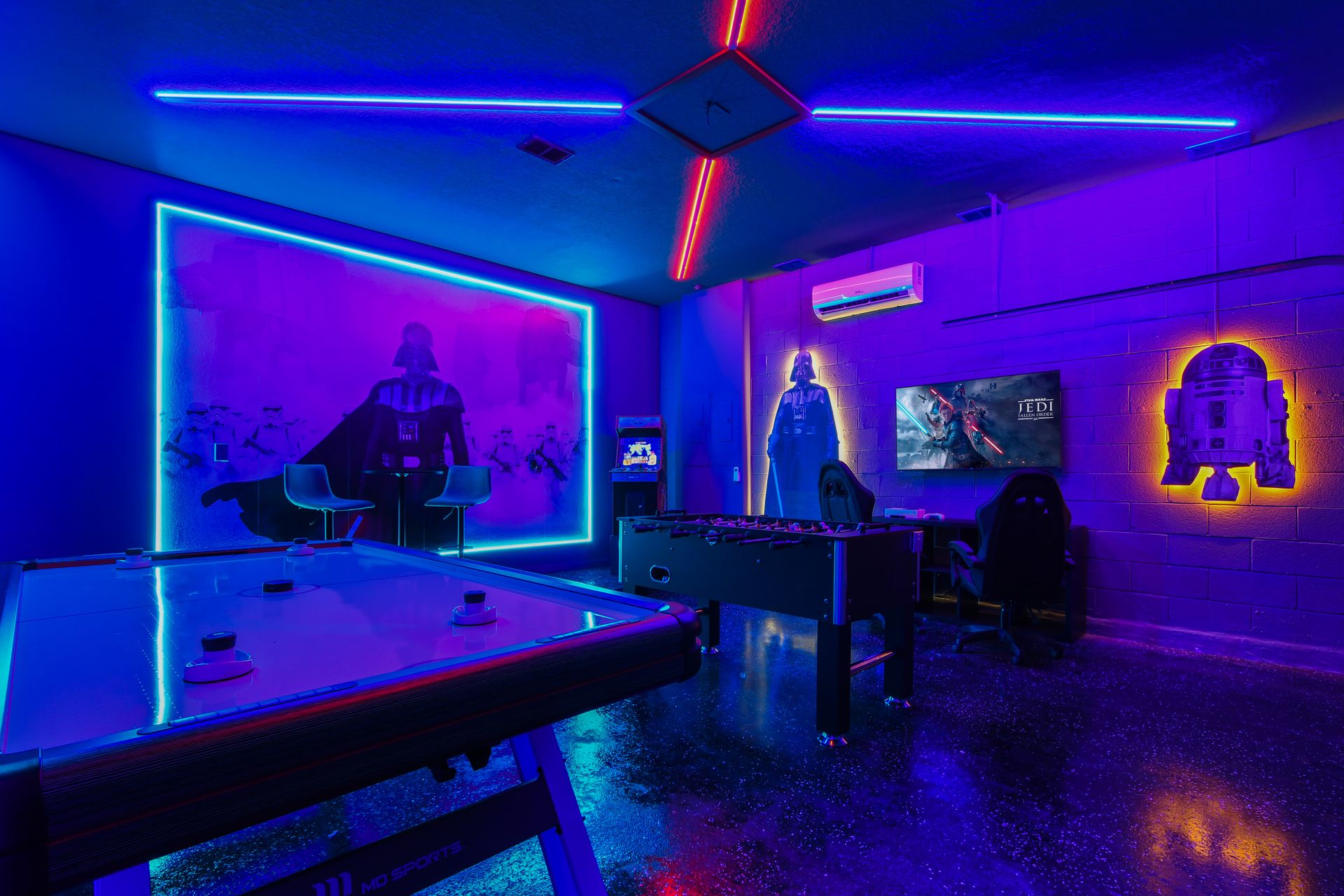 Galactic game room with air hockey, foosball, arcade, and glowing Star Wars decor.
