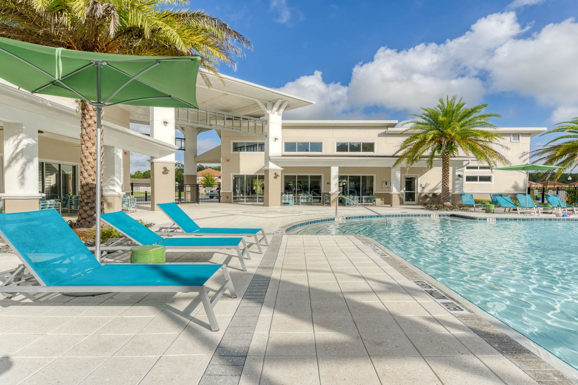 Relax in paradise with a resort-style pool, luxury loungers, and palm-lined views