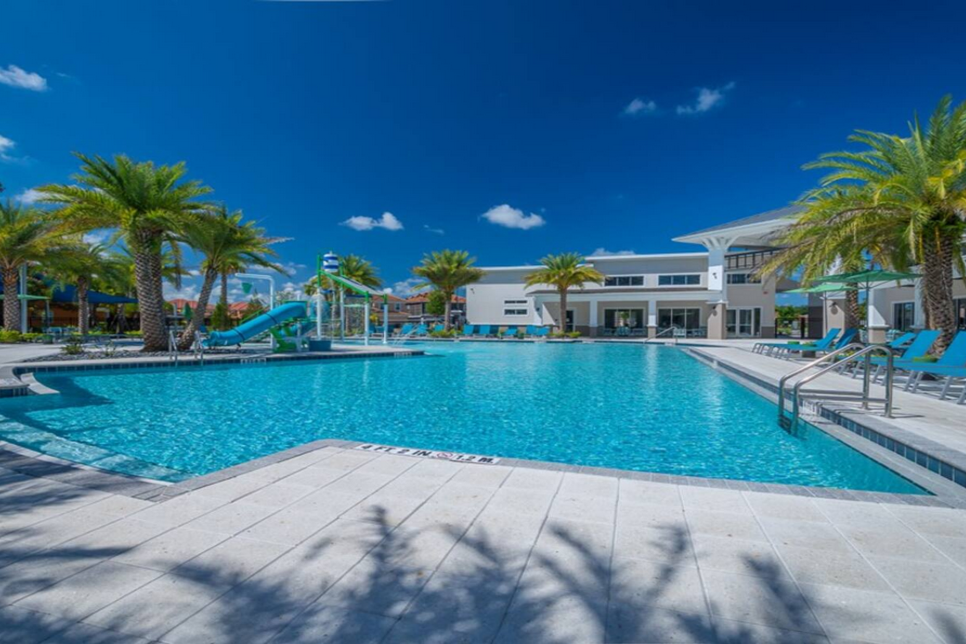 Resort-style pool with waterslides, palm trees, and plenty of space to relax and unwind