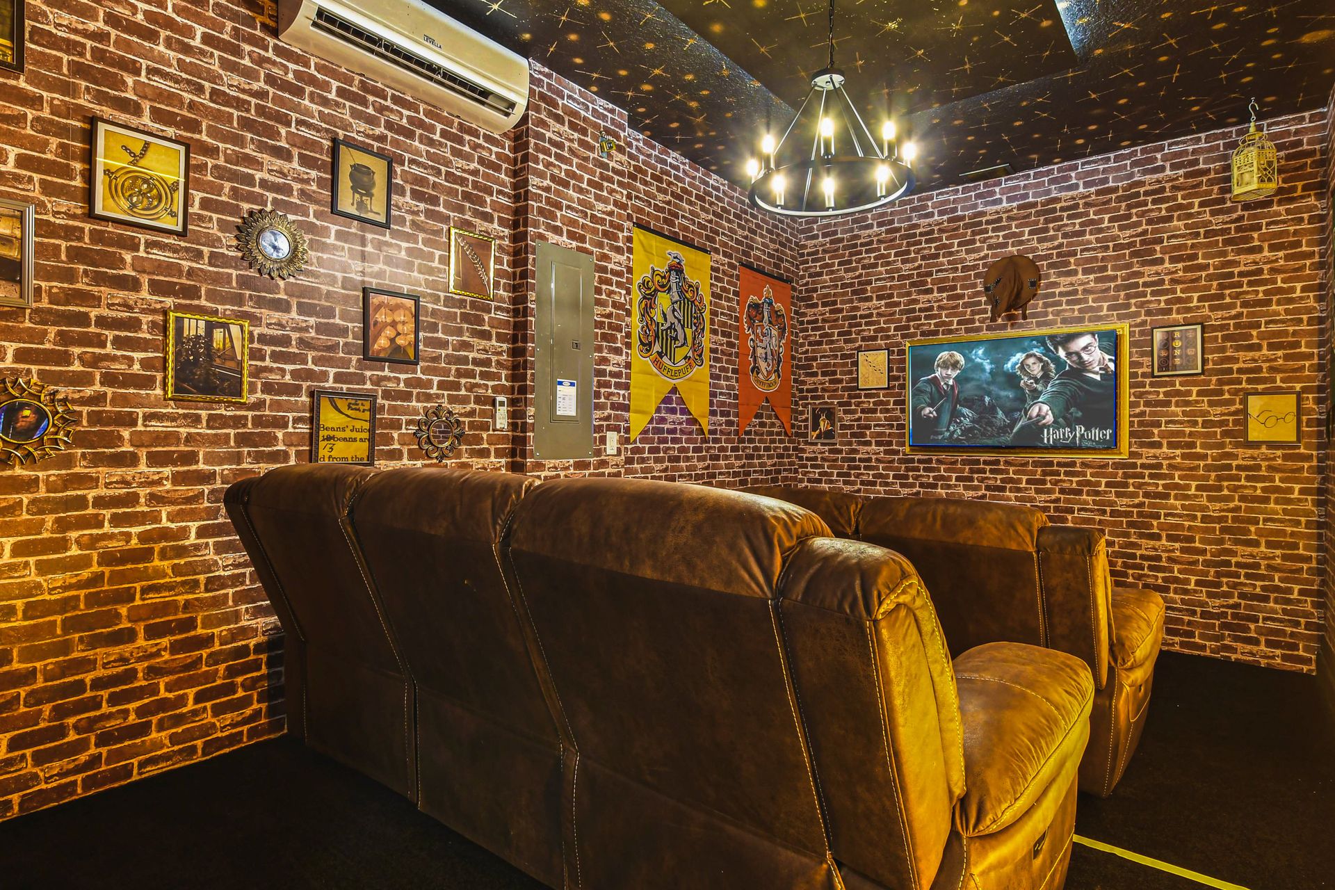 Harry Potter-themed movie room with Hogwarts banners, starry ceiling, cozy seating.