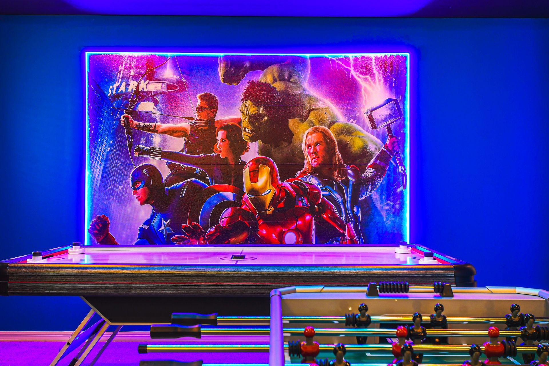 Avengers game room with air hockey, foosball, and epic hero wall art.