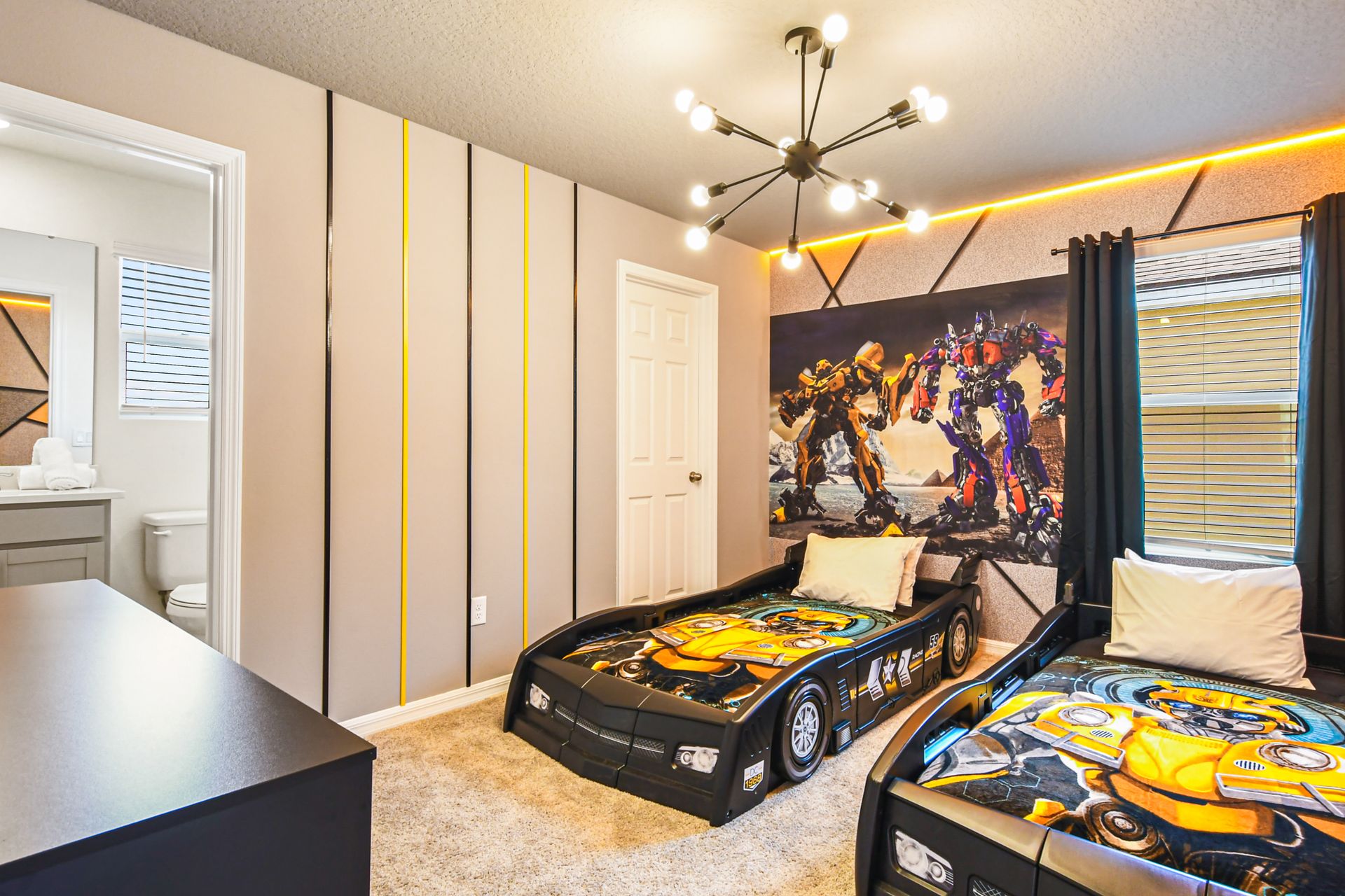 Transformers-themed twin room with car beds and bold lighting for young heroes.