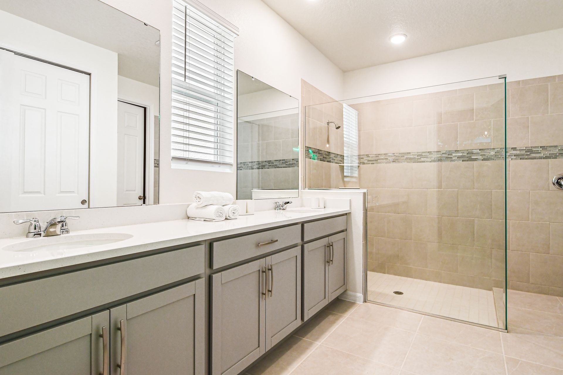 Relax in this spacious bathroom featuring dual sinks and a large walk-in shower.