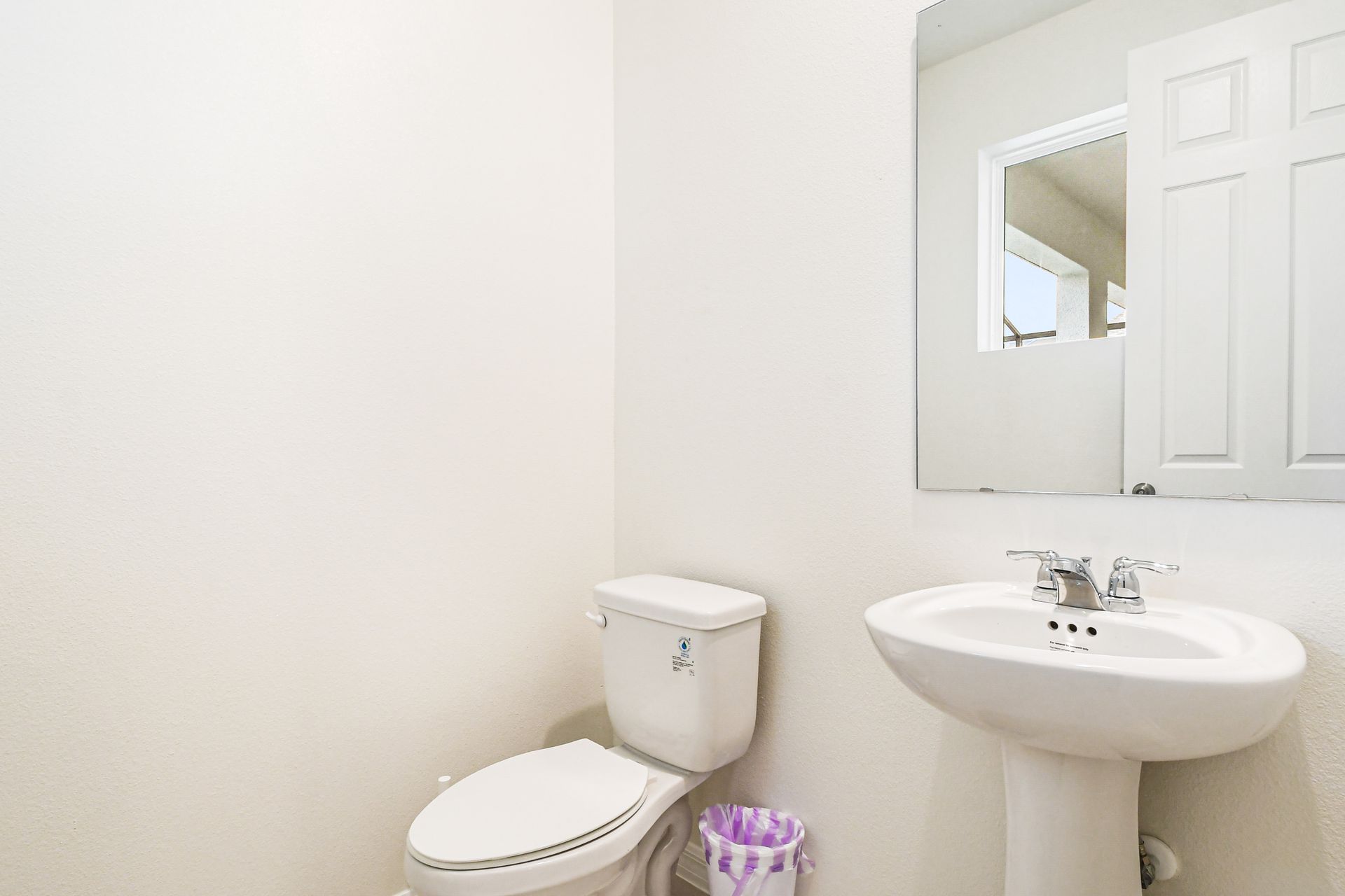 Convenient half bath with pedestal sink, located near the main living area.