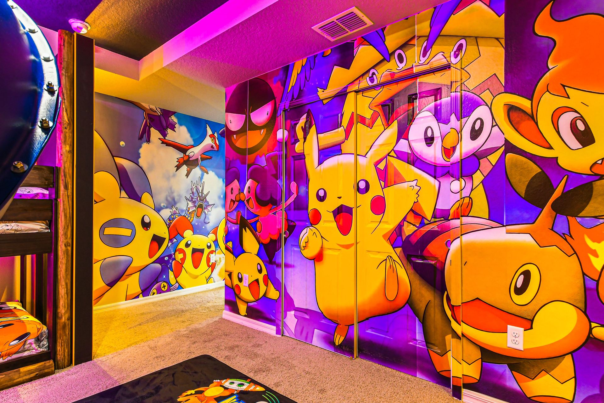 Colorful Pokémon-themed room with bunk beds, vibrant murals, and playful lighting.
