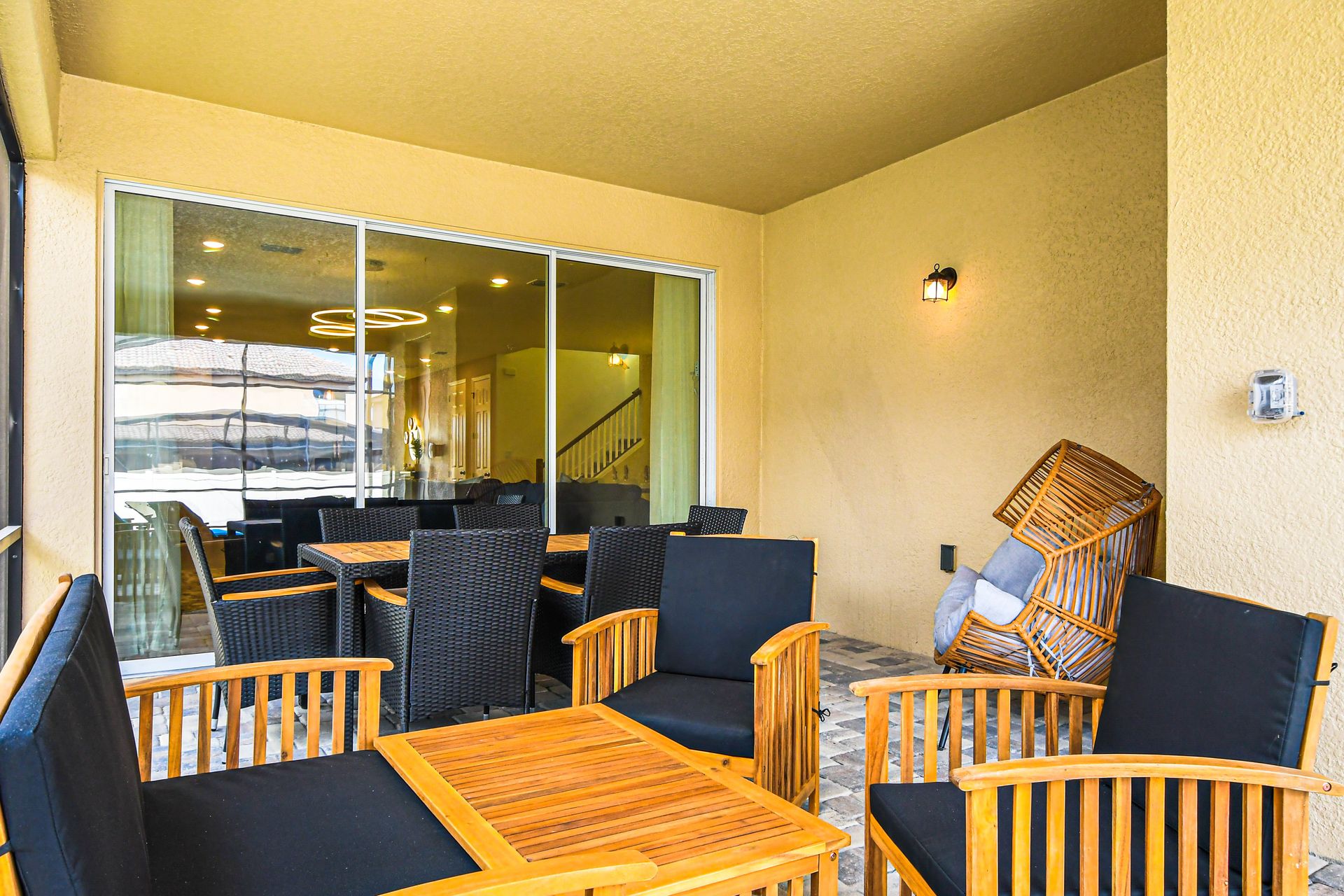 Cozy screened patio with wood seating, dining area, and warm lighting.