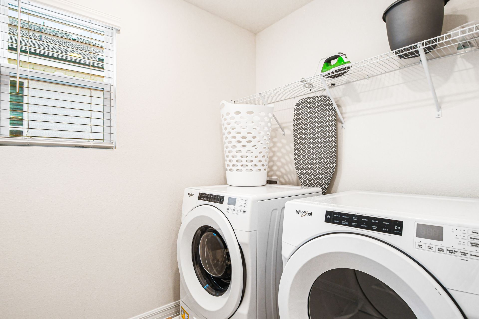 Convenient laundry room with modern appliances, shelving, and natural light.