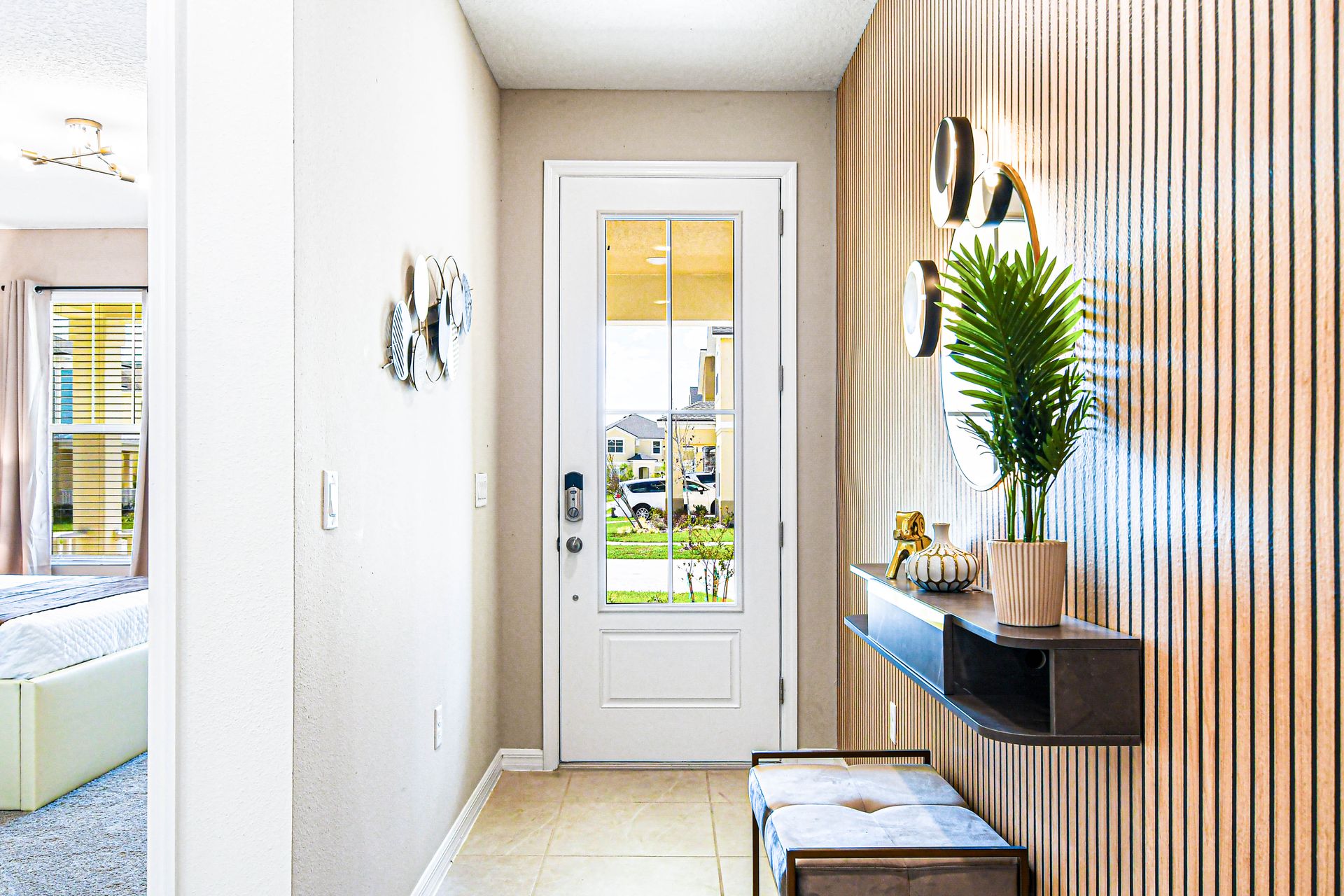 Modern entryway with wood accent wall, stylish decor, and natural light.