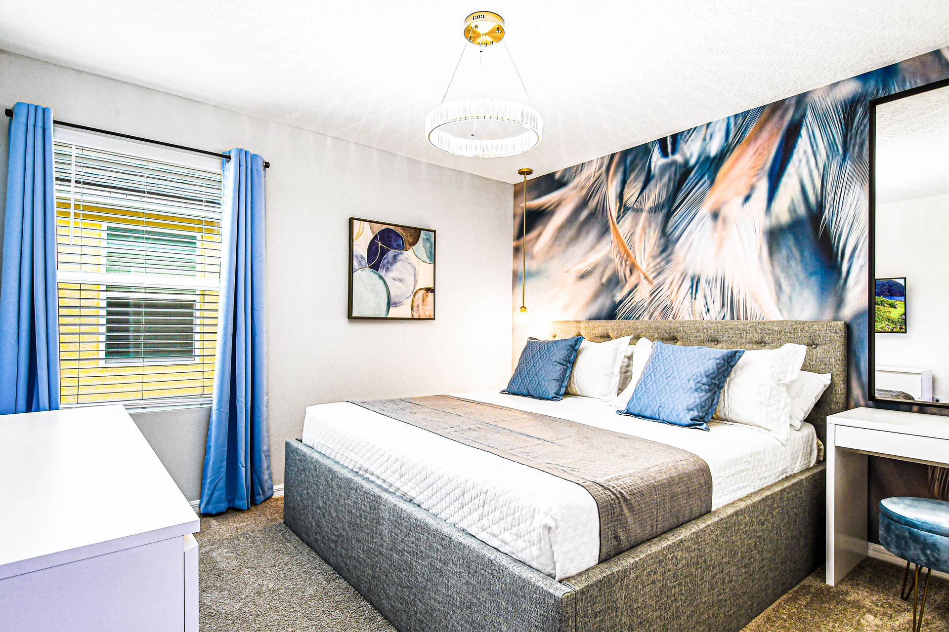 Serene bedroom with feather accent wall, soft tones, and cozy seating.