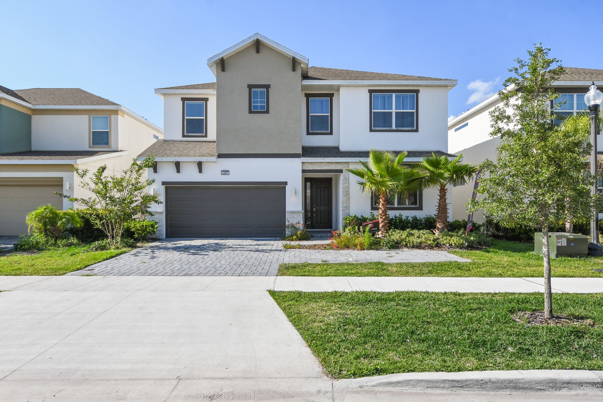 Modern two-story home with landscaped yard, spacious driveway, and garage.