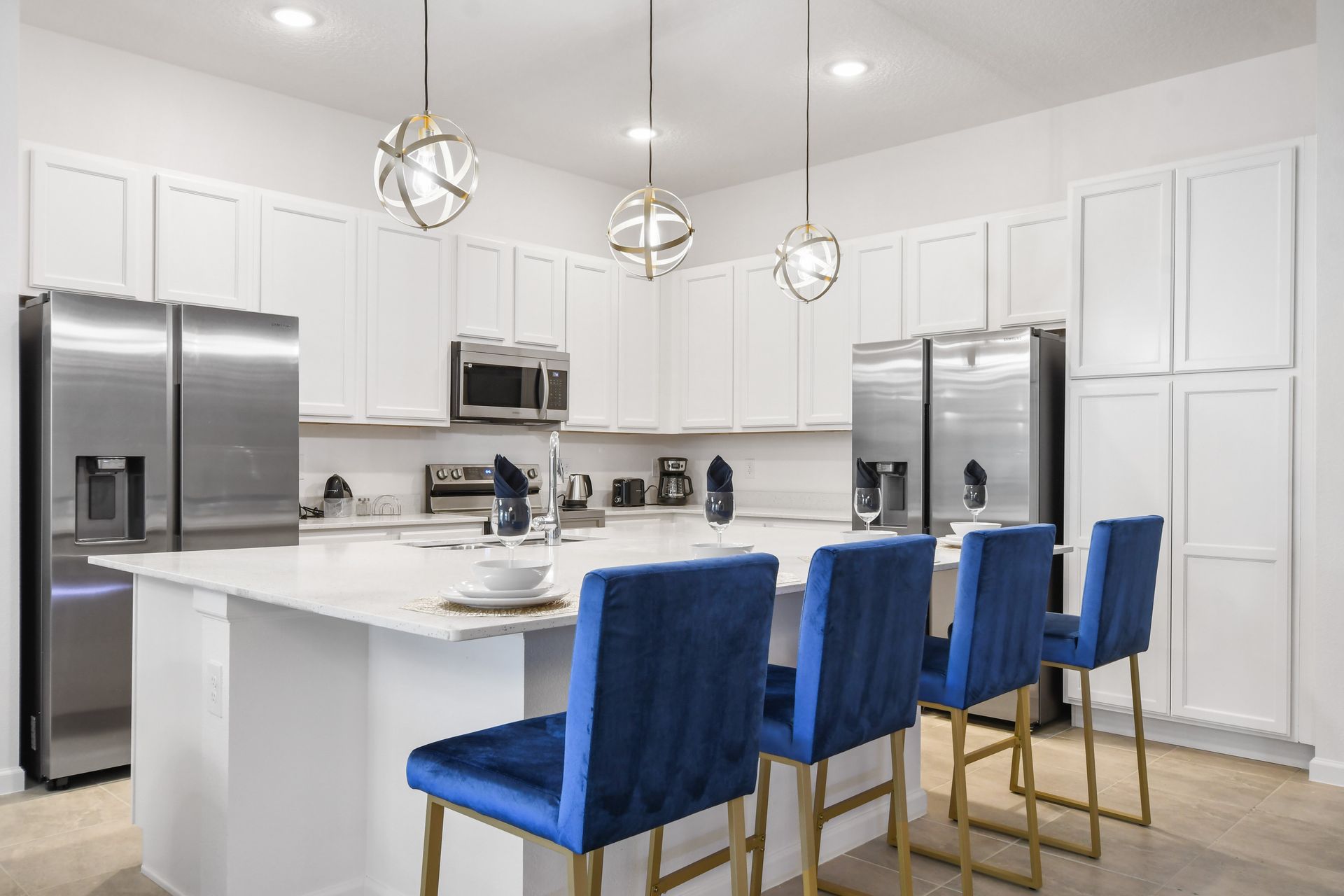 Modern kitchen with sleek appliances, island seating, and elegant lighting.