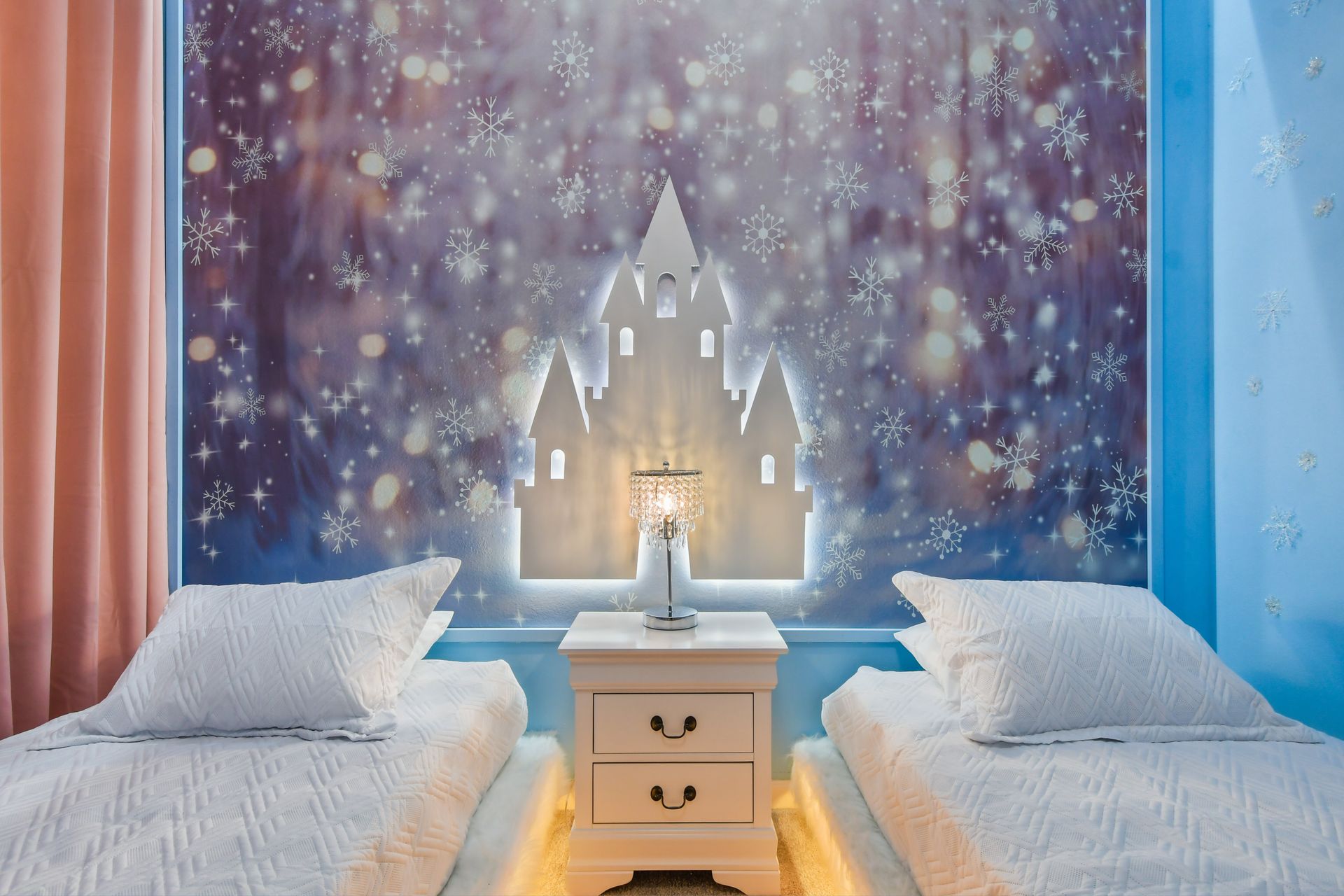 Fairy-tale themed room with snowflake decor, cozy beds, and soft lighting.