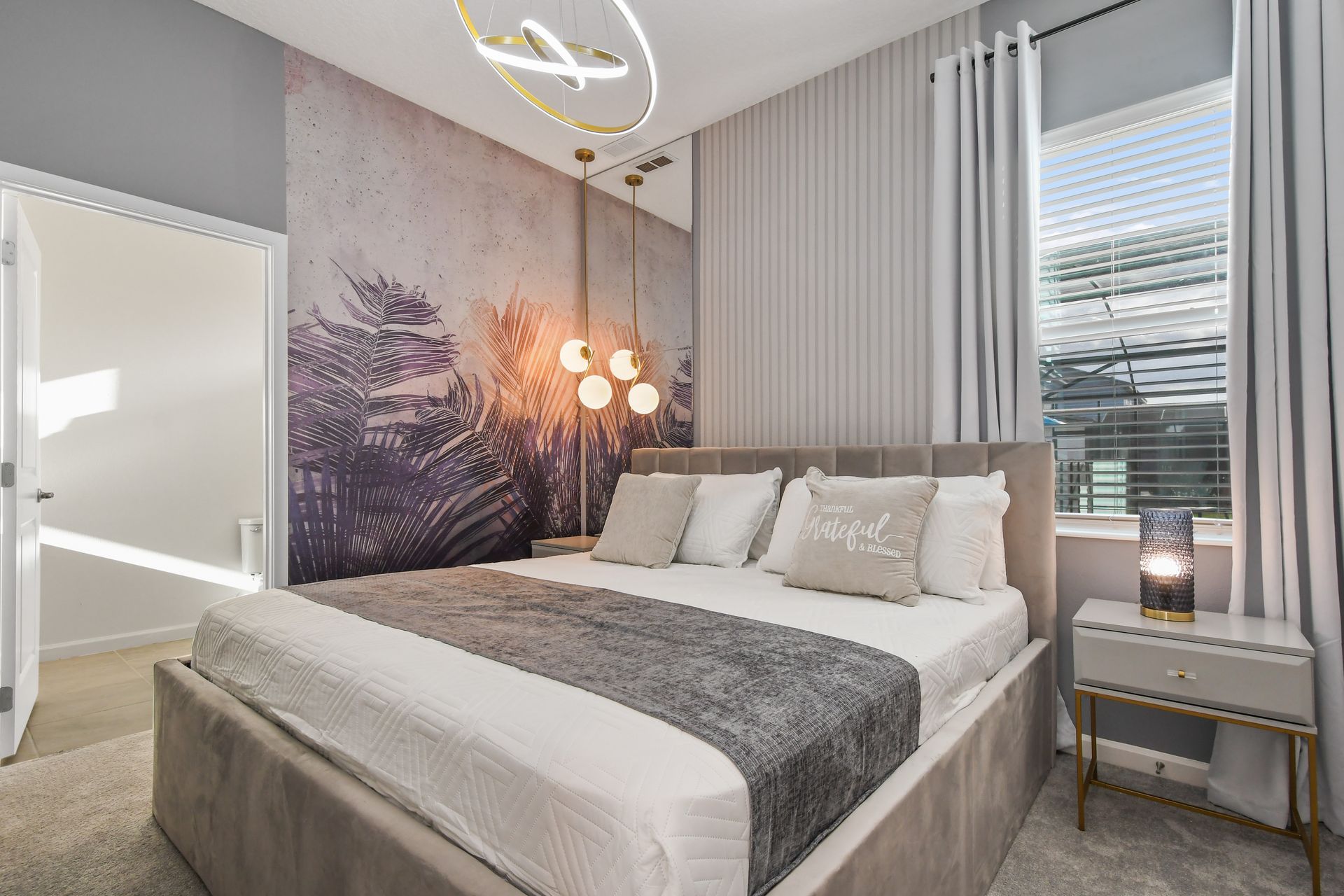 Modern bedroom with soft tones, palm accents, and elegant lighting for relaxation.