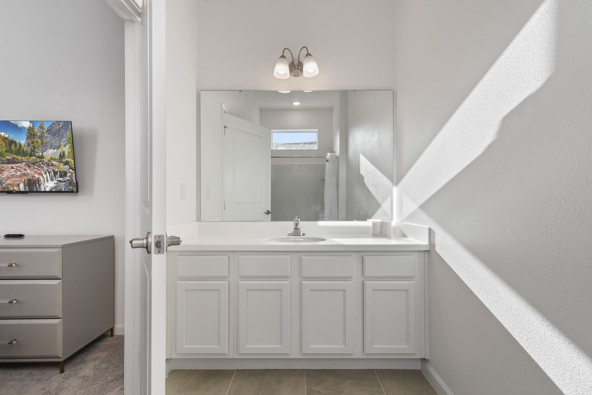 Bright and simple bathroom with natural light and a clean white vanity.