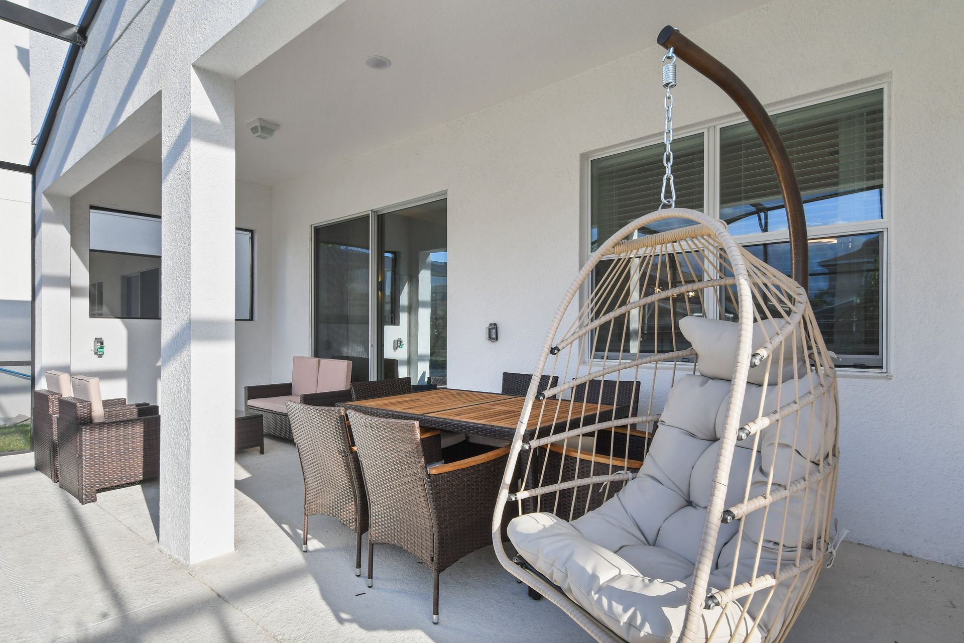 Covered patio with outdoor seating, dining area, and pool views for relaxing.