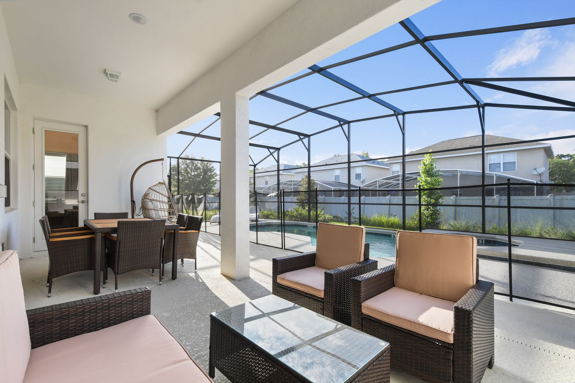 Covered patio with outdoor seating, dining area, and pool views for relaxing.