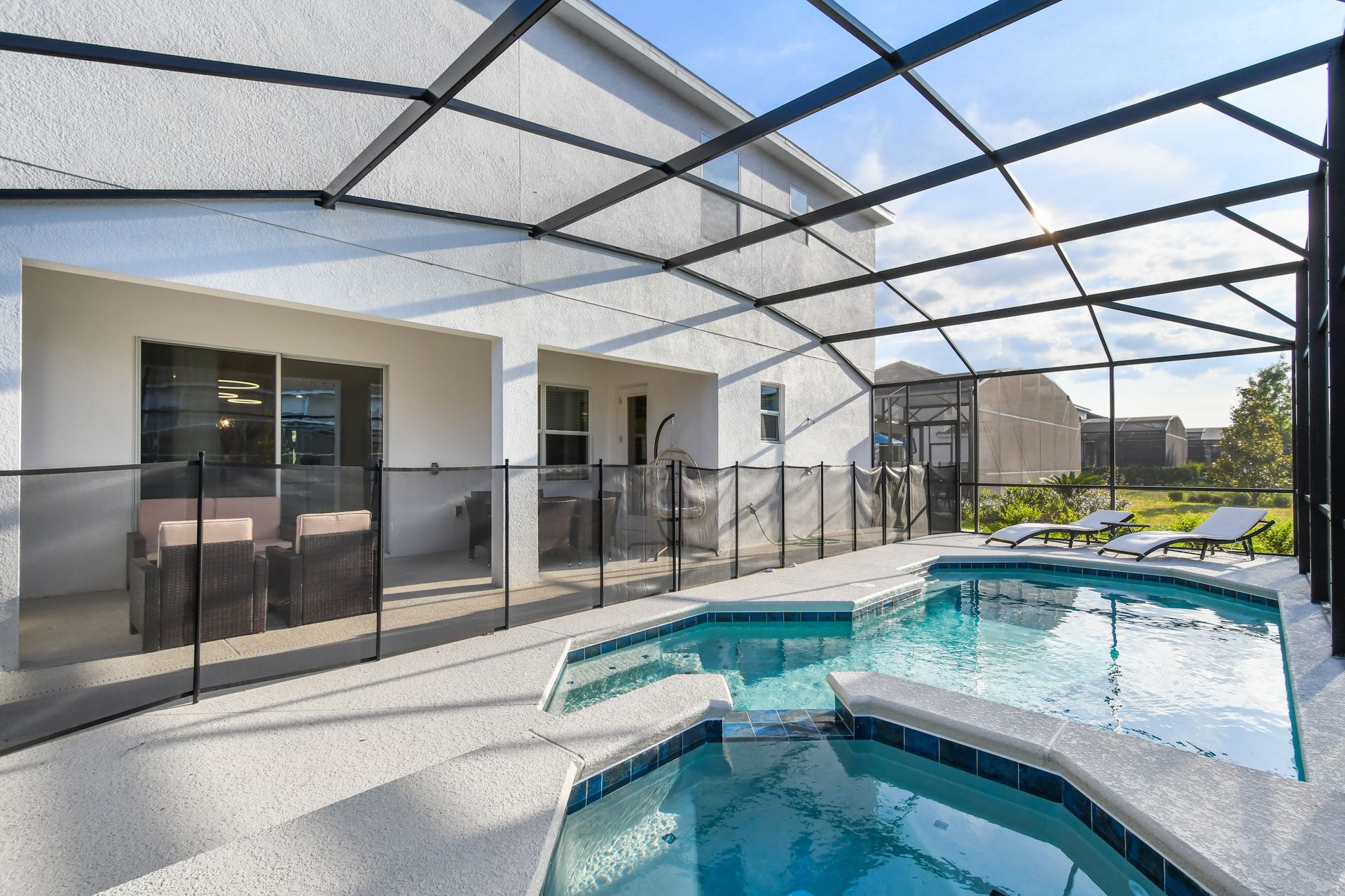 Private screened pool and spa with lounge chairs and sunny garden views.