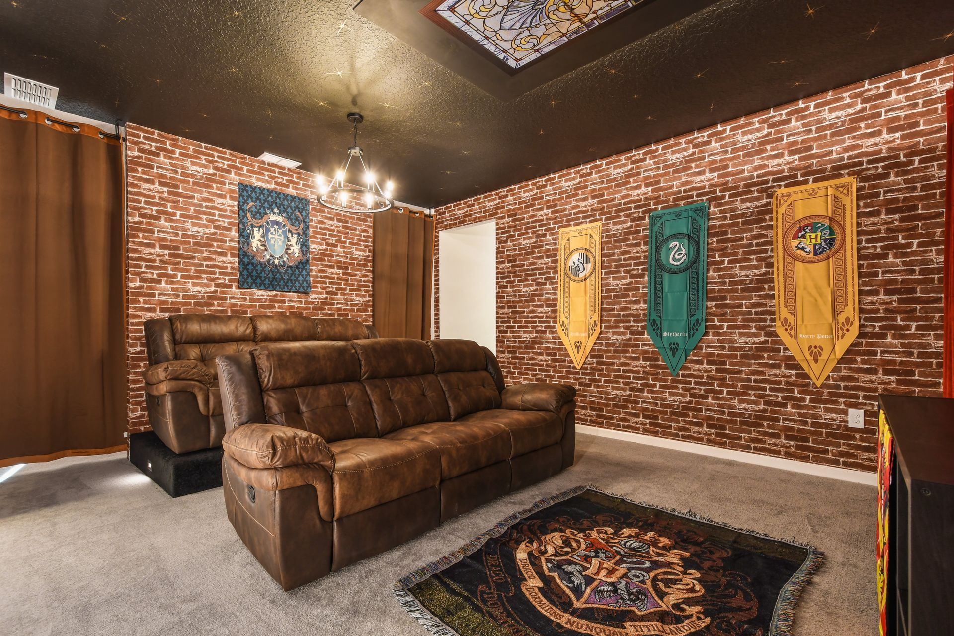 Wizard-themed theater room with cozy seating, brick walls, and house banners.