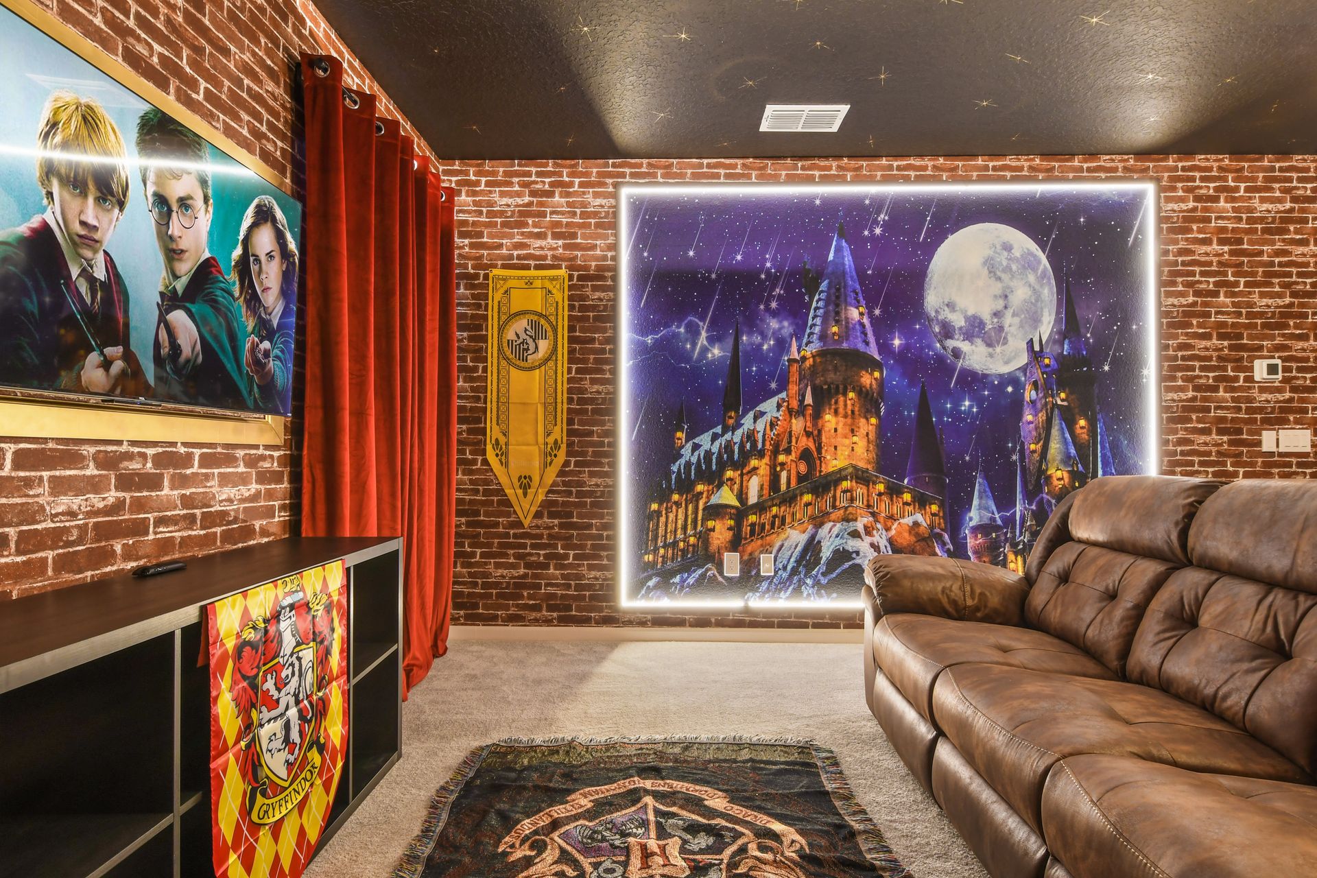 Wizard-themed theater room with cozy seating, brick walls, and house banners.