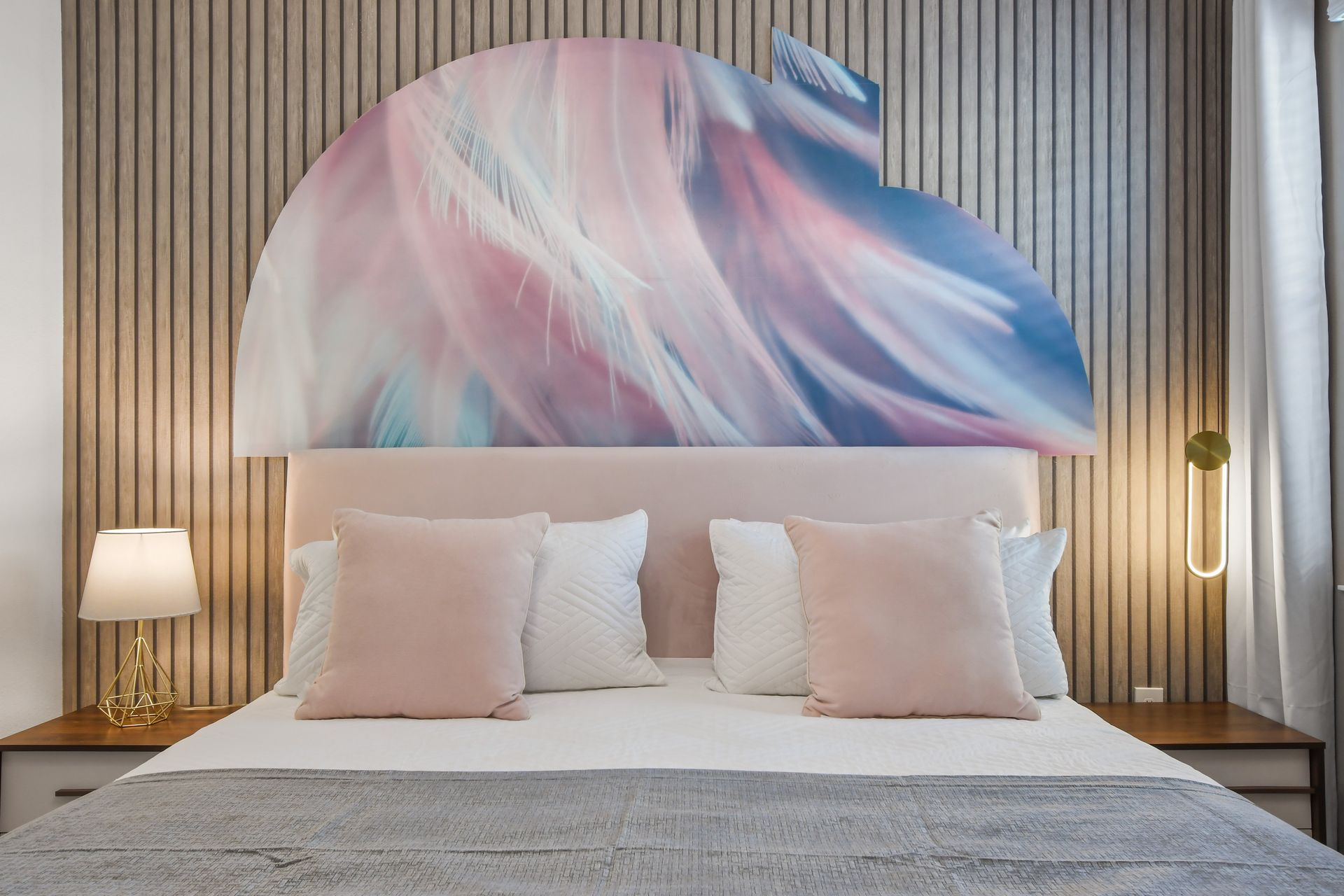 Chic bedroom with soft pastels, modern decor, and a statement chandelier.