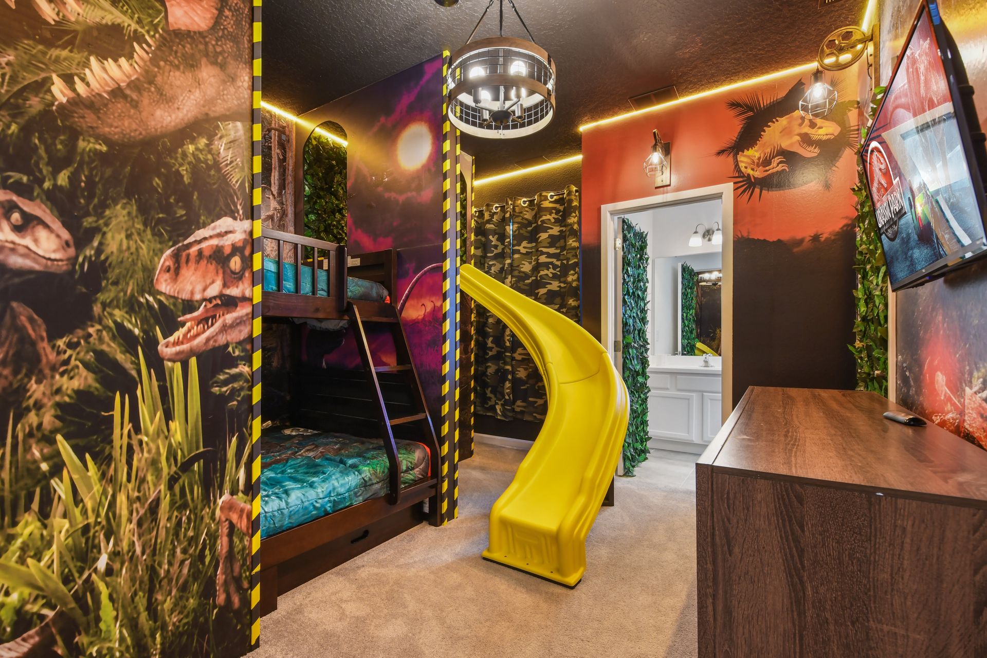 Dinosaur-themed room with bunk beds, slide, and jungle decor near attractions.