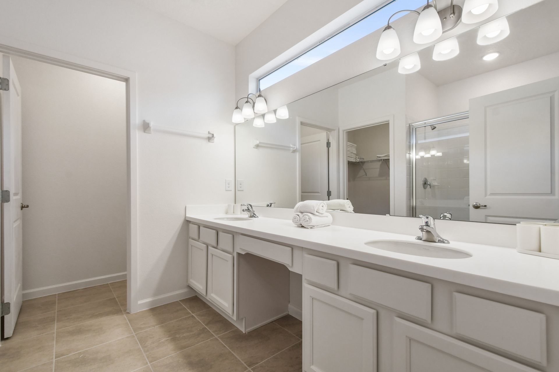 Spacious bathroom with double vanity, bright lighting, and modern fixtures.
