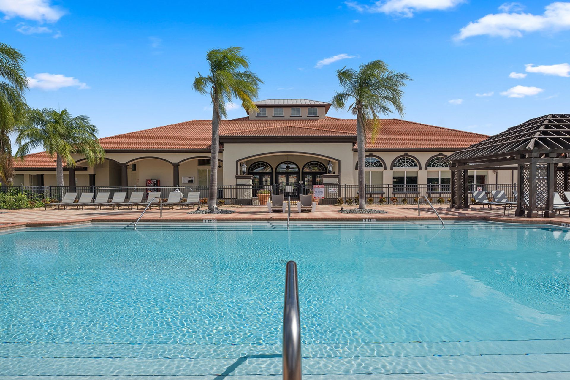 Luxurious poolside retreat with cabanas, loungers, and palm views!
