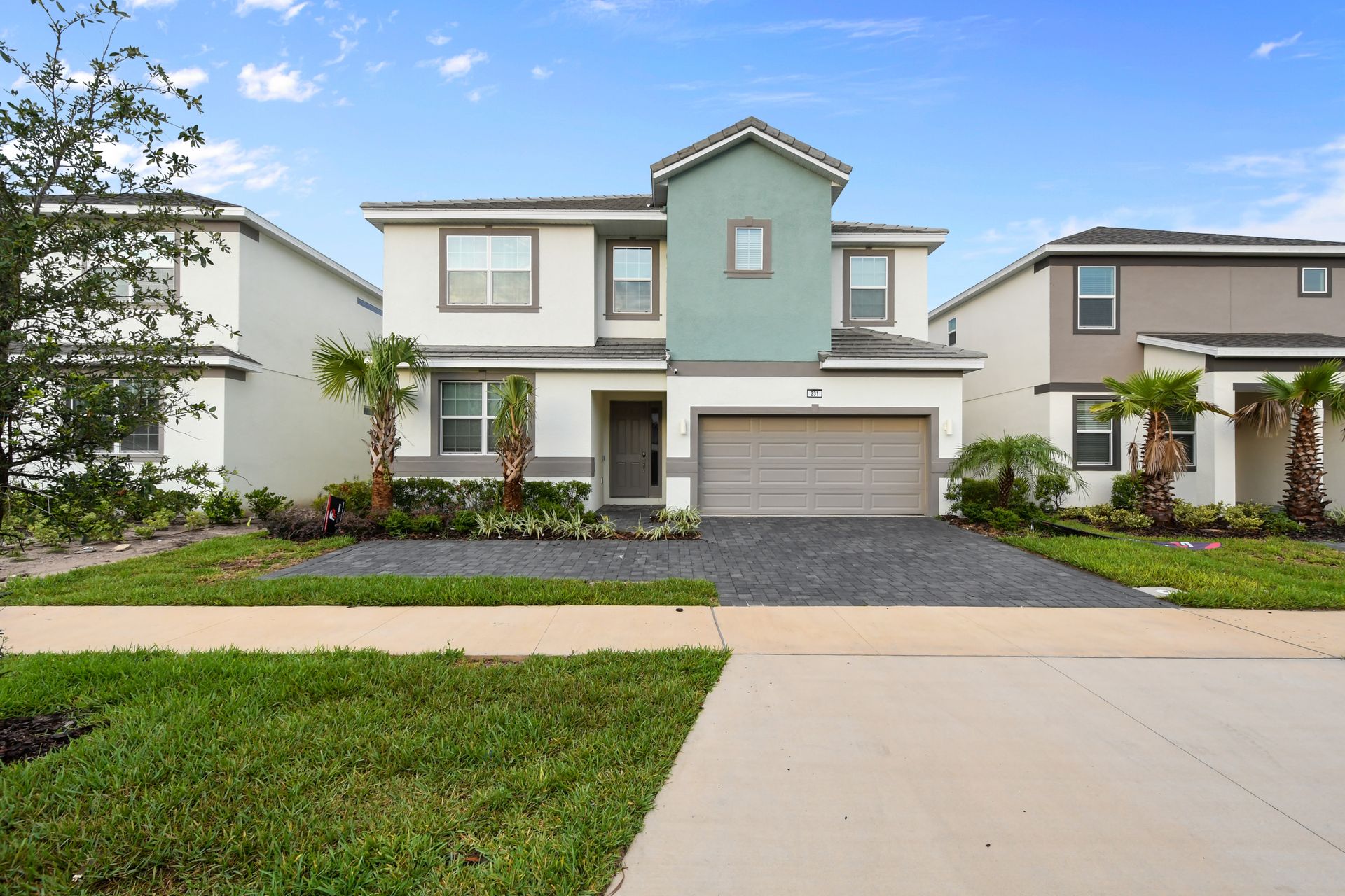 Modern 2-story villa with garage, palm-lined entry, and fresh curb appeal
