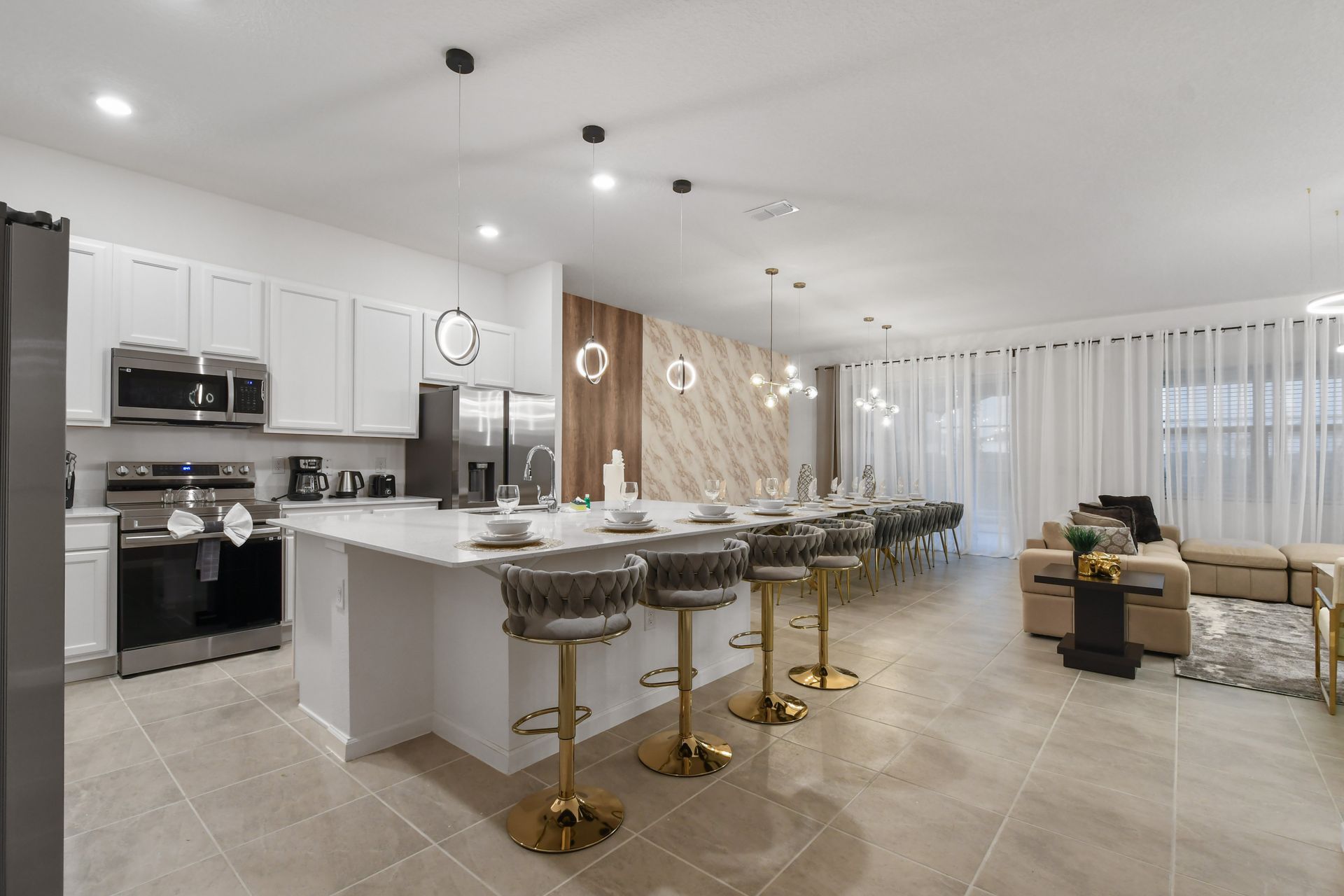 Modern chef’s kitchen with marble-style dining, luxe seating, and open living flow
