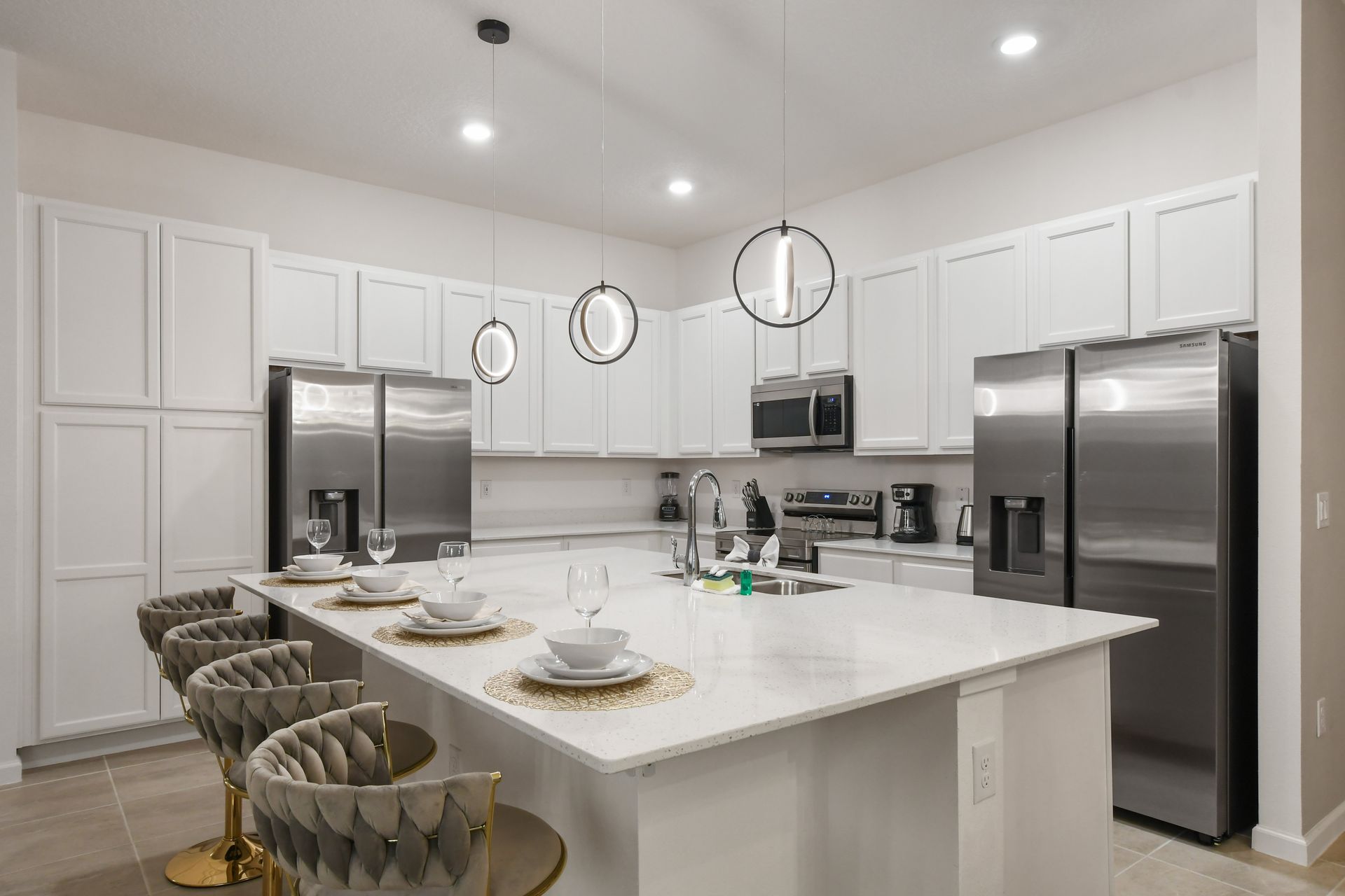Sleek modern kitchen with quartz island, stainless appliances, and stylish seating
