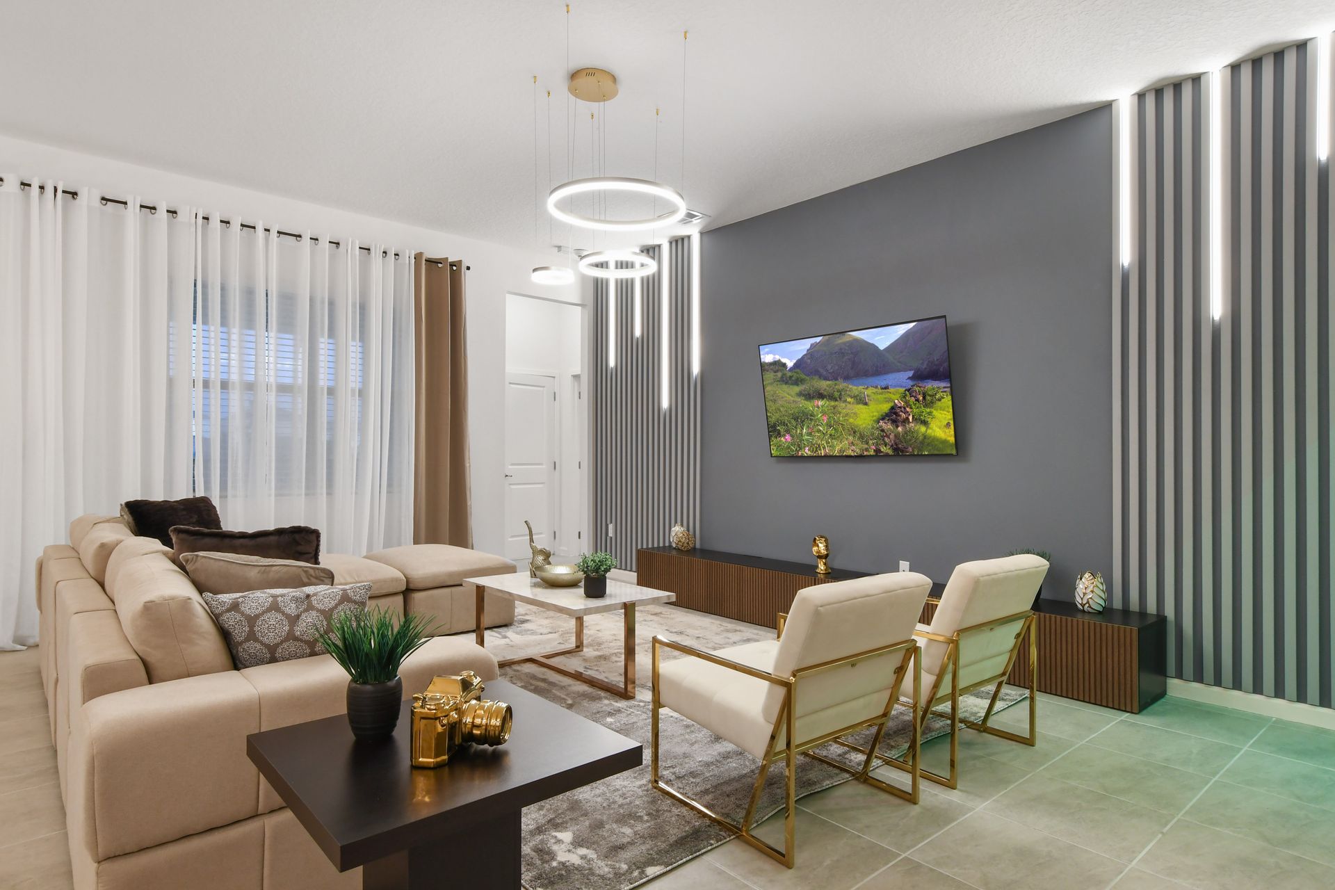 Gather in the inviting living area featuring plush sofas, a large flat-screen TV, and an open concept design perfect for relaxation and bonding.