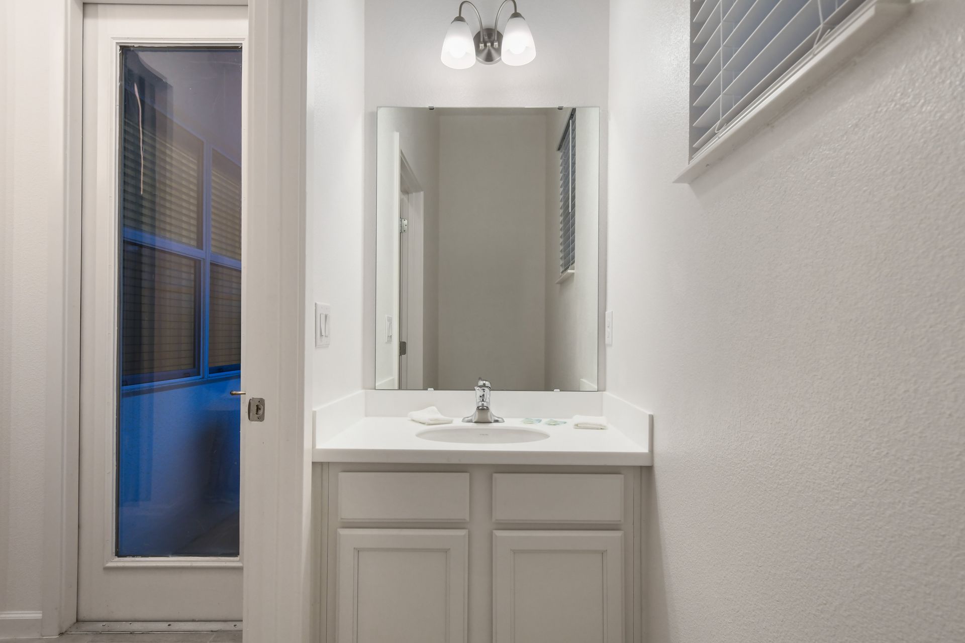 Poolside half bath with sleek vanity, ideal for quick rinses and easy outdoor access
