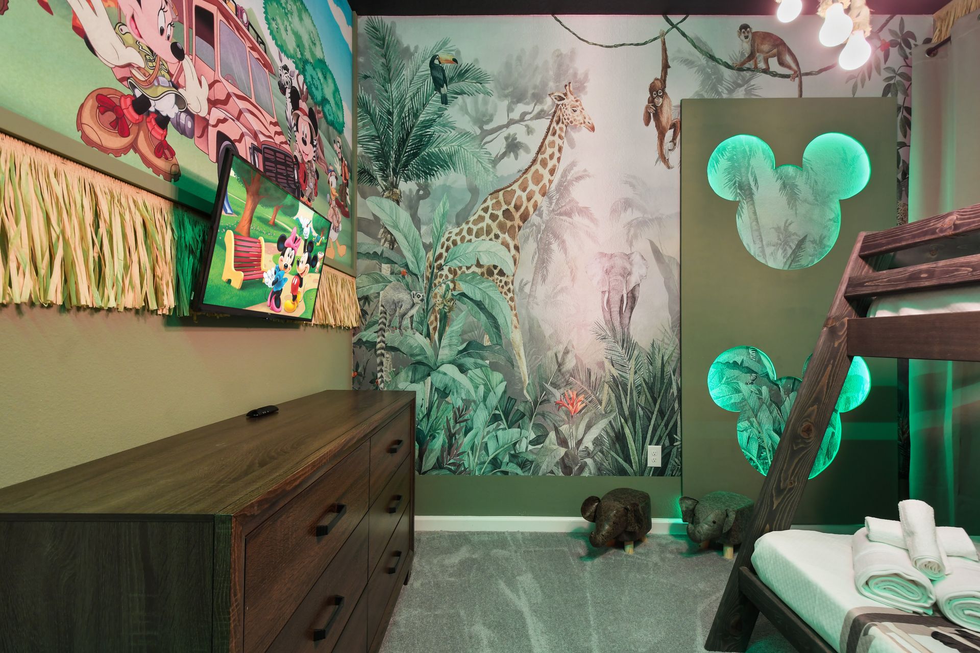 Whimsical jungle-themed kids room with Mickey accents and cozy bunk beds
