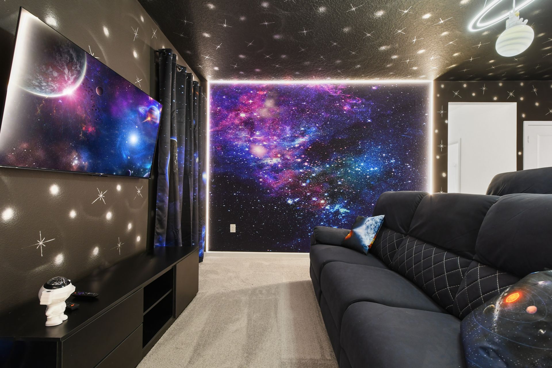 Cosmic home theater with galaxy walls, starry ceiling, and plush reclining seats
