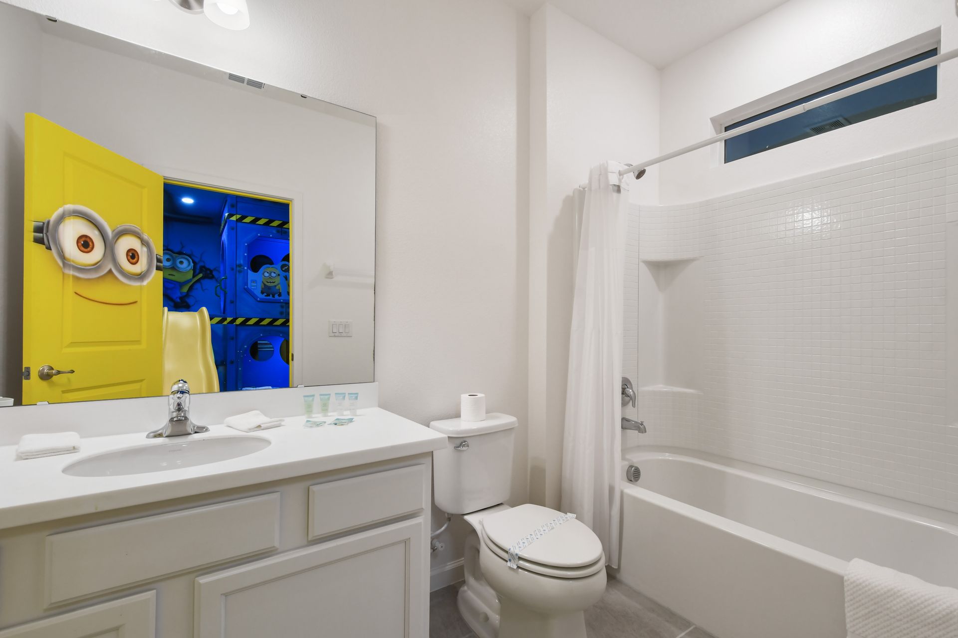 Fun and functional bathroom with tub-shower combo, perfect for the Minion-themed room nearby

